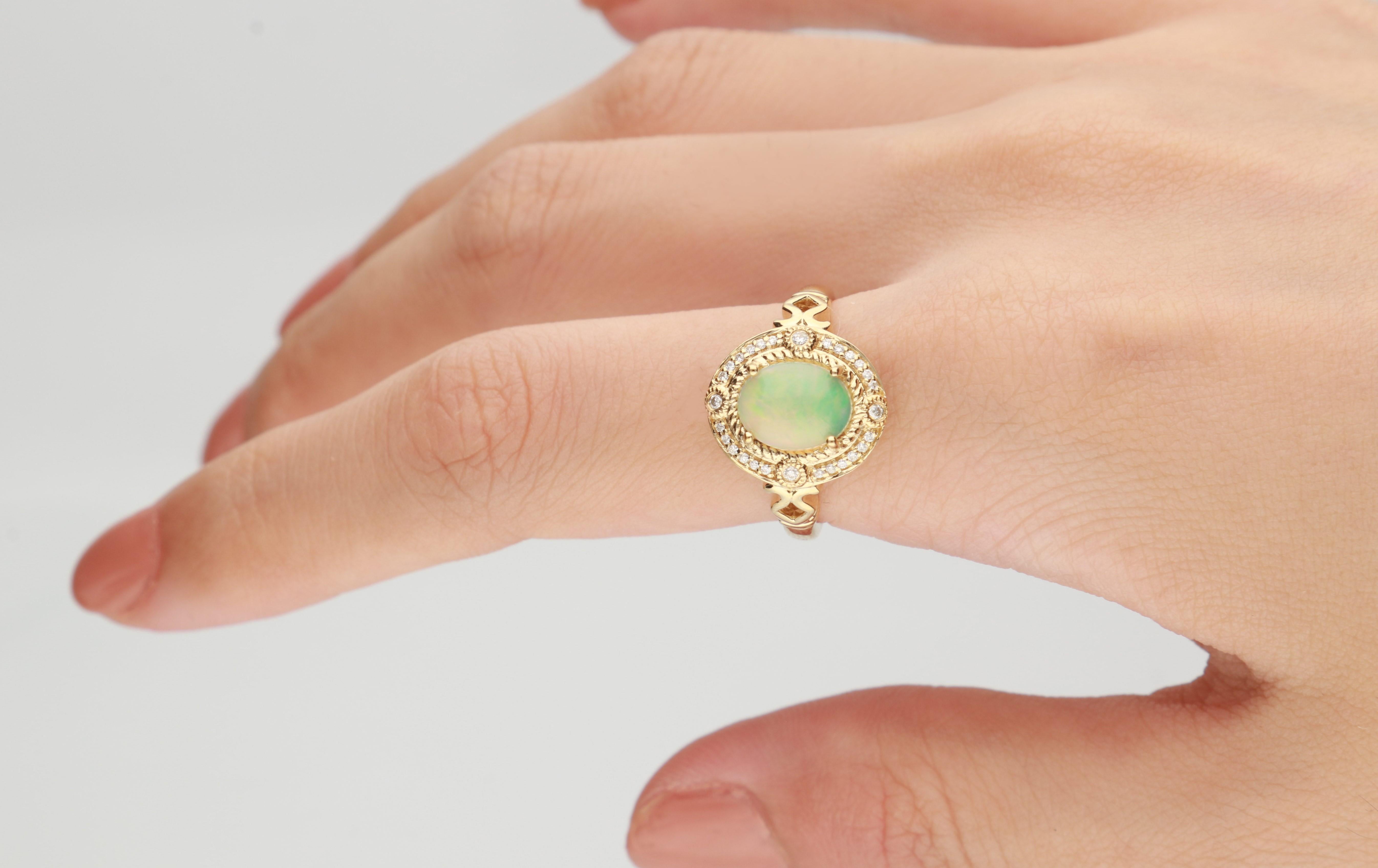 Questo bellissimo anello con opale naturale è realizzato in oro giallo 14 carati e presenta un'opale naturale da 1,27 carati e 28 diamanti bianchi rotondi di qualità GH- I1 con 0,10 carati incastonati. Questo anello è disponibile nelle taglie dalla