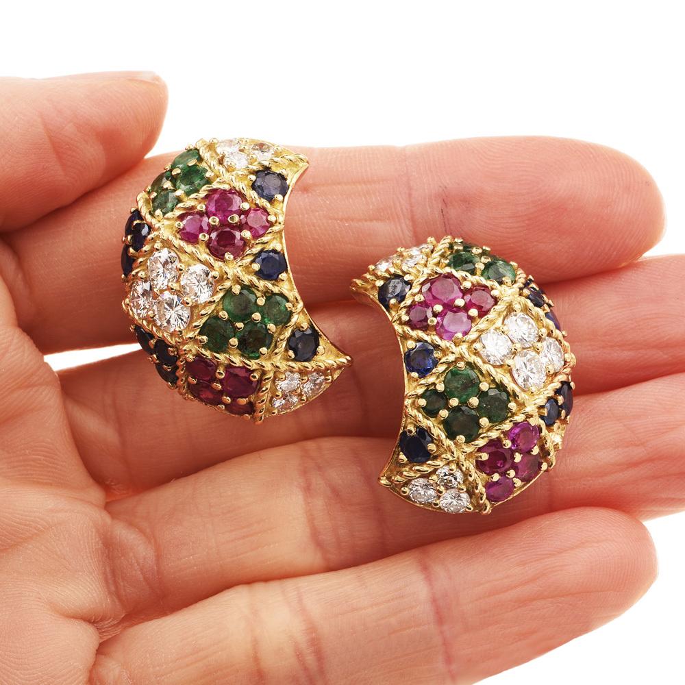 These stunning diamond, ruby, sapphire and emerald earrings are crafted 18-karat yellow gold, weighing 21.5 grams and measuring 27mm x 18mm. Embellished with 20 high quality prong-set round-cut diamonds, collectively weighing 3.12 carats, graded F-G