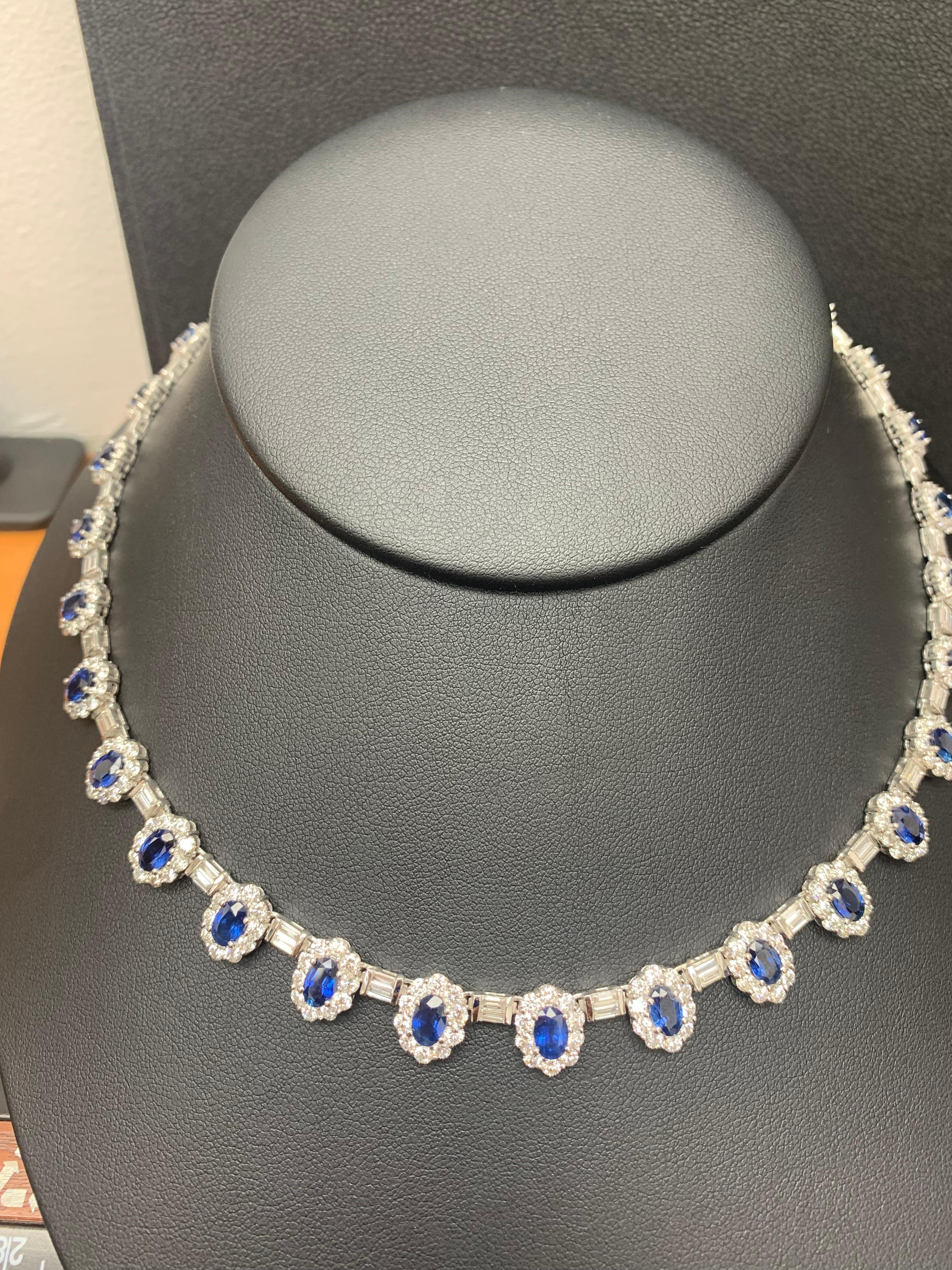 A unique and chic necklace showcasing 31 oval cut blue sapphire, surrounded by 1 row of round brilliant diamonds and connecting these gorgeous halo blue sapphires are baguette diamonds. Sapphires weigh 12.74 carats total; Round diamonds weigh 15.32