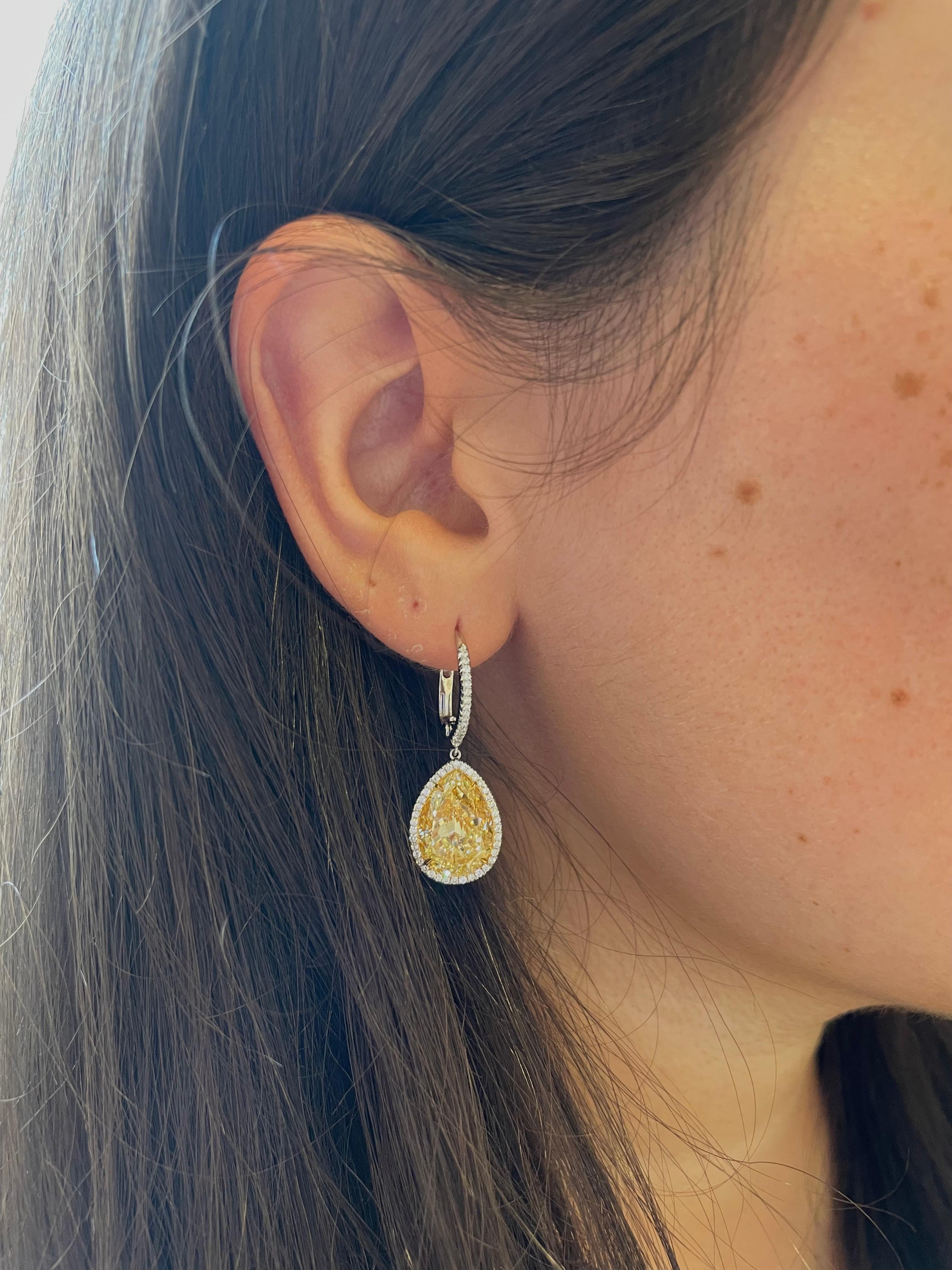 These spectacular yellow diamond earrings are like wearing drops of sunshine! This beautifully matched pair of pear shaped yellow diamonds are certified by GIA as Fancy Yellow color and VS2 clarity, and together they total 12.16 carats. A delicate