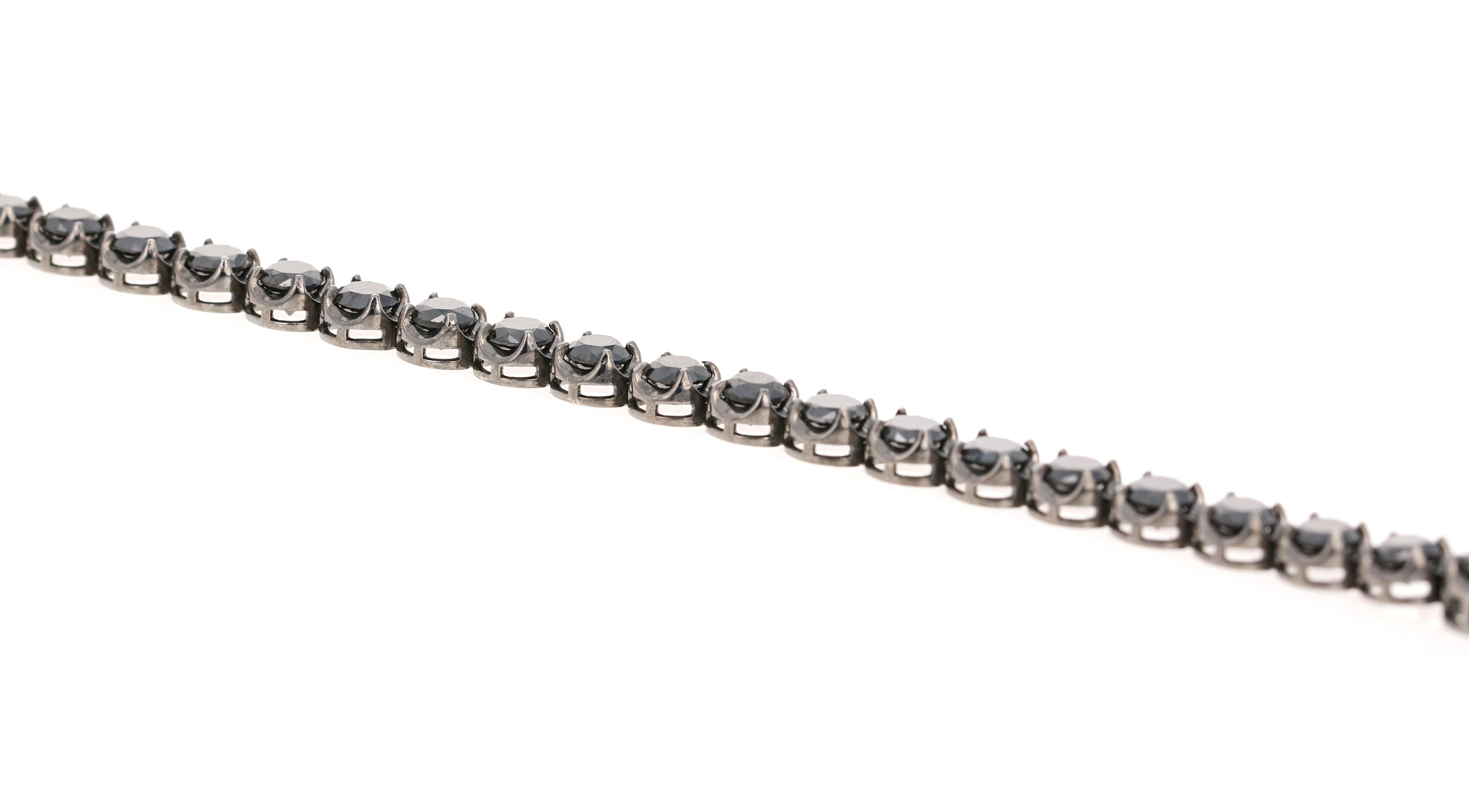 Curated in 14 Karat Gold, this piece has black rhodium to match the black diamonds.

It has 27 Round Cut Black Diamonds that weigh 12.78 Carats and is 7.5 inches long with an appproximate weight of 14.0 grams.

