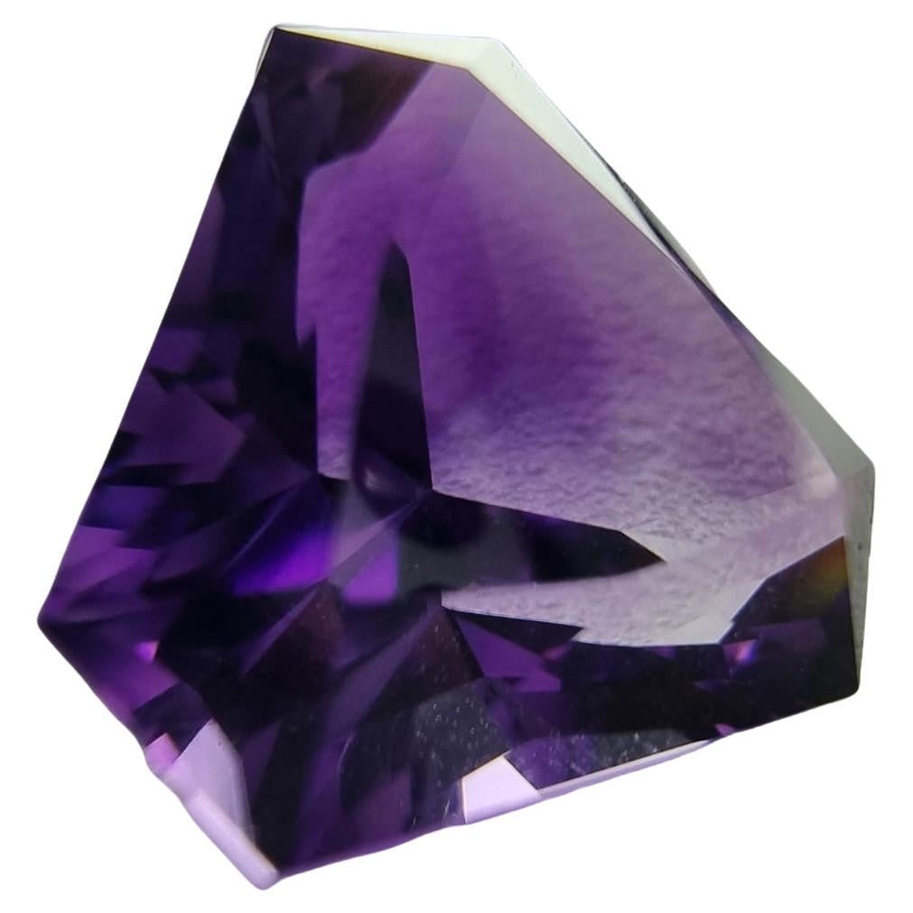 Introducing our stunning 12.7ct Triangular Cut Amethyst Loose Gemstone, a dazzling masterpiece that combines size, shape, and color in perfect harmony. This exceptional gemstone boasts a generous weight of 12.7 carats, making it a statement piece