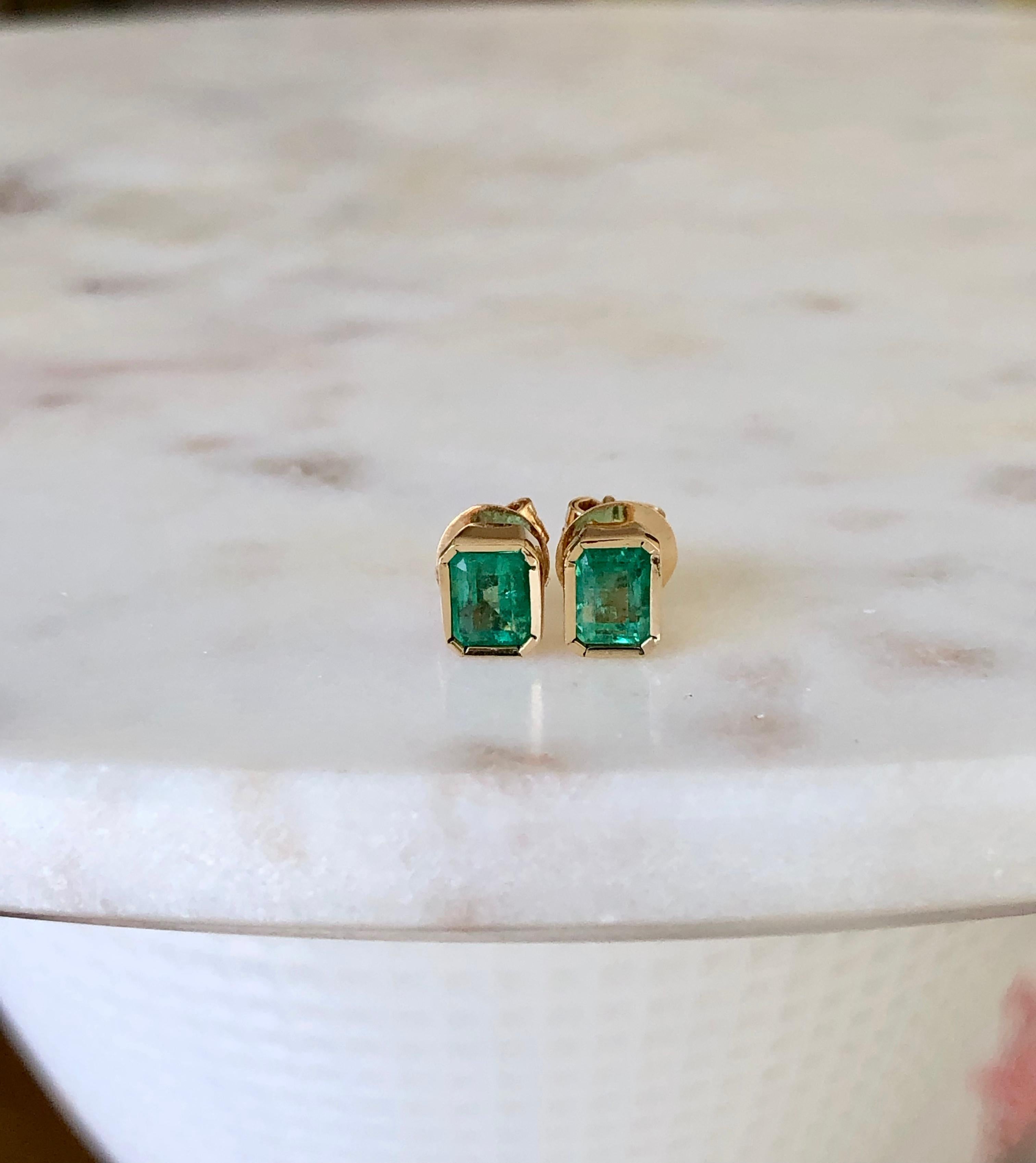 Colombian Emerald Studs Earrings 18K 
Average Color/Clarity : Fine Medium Green/ Clarity VS
Total Weight :  Approx 1.28 carats (2 Emerald) 
Earrings Measurement: 6.80mm x 5.30mm
Style: Bezel set / Push Backs
Composition: Yellow Gold 18K
Condition: