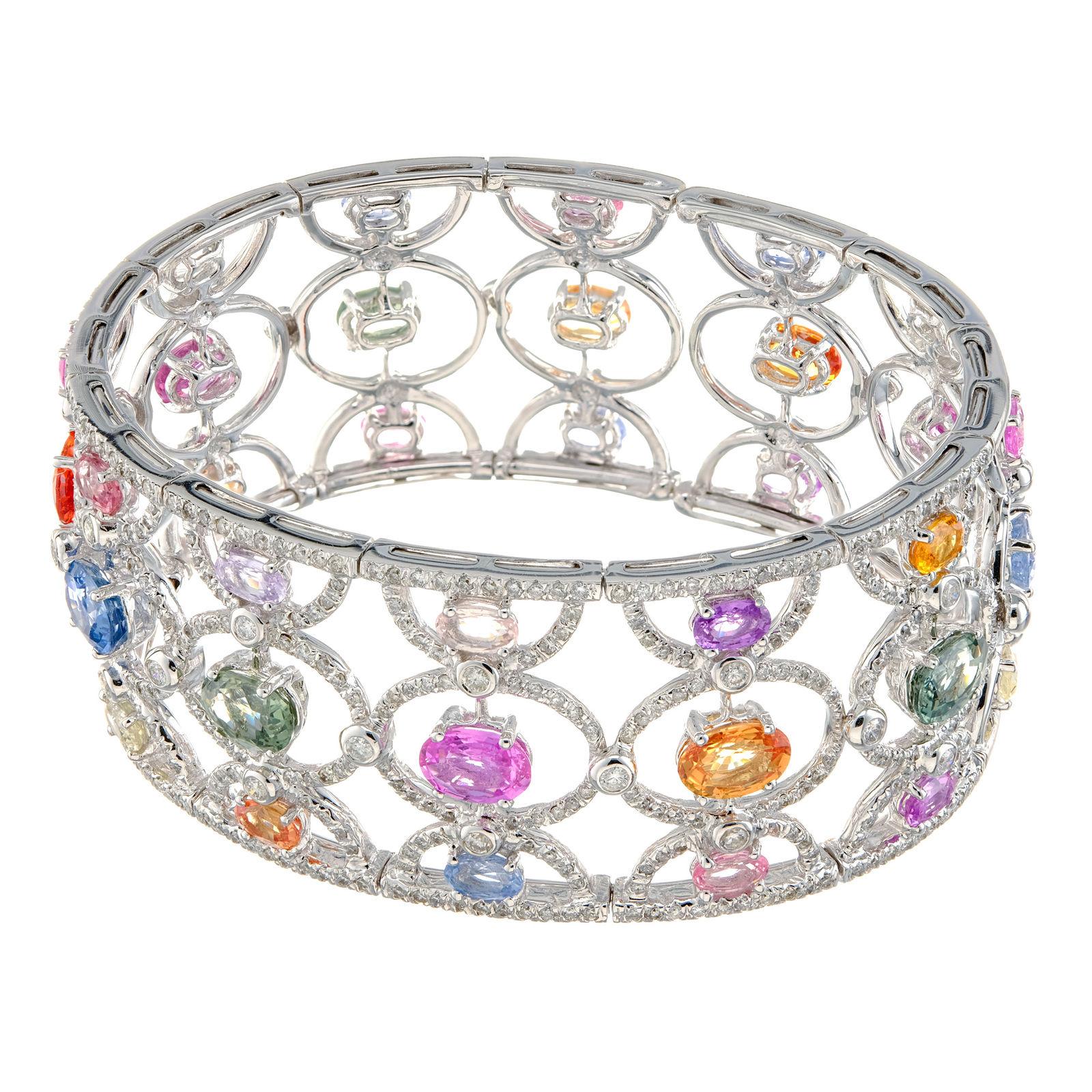 GIA certified. Multi-color sapphire and white diamond cuff bangle bracelet. Oval sapphires purple, pink, green, orange, accented with round diamonds in an open work 18k white gold bracelet.

36 Oval Multi-Color Sapphires. Approx. Total Weight.