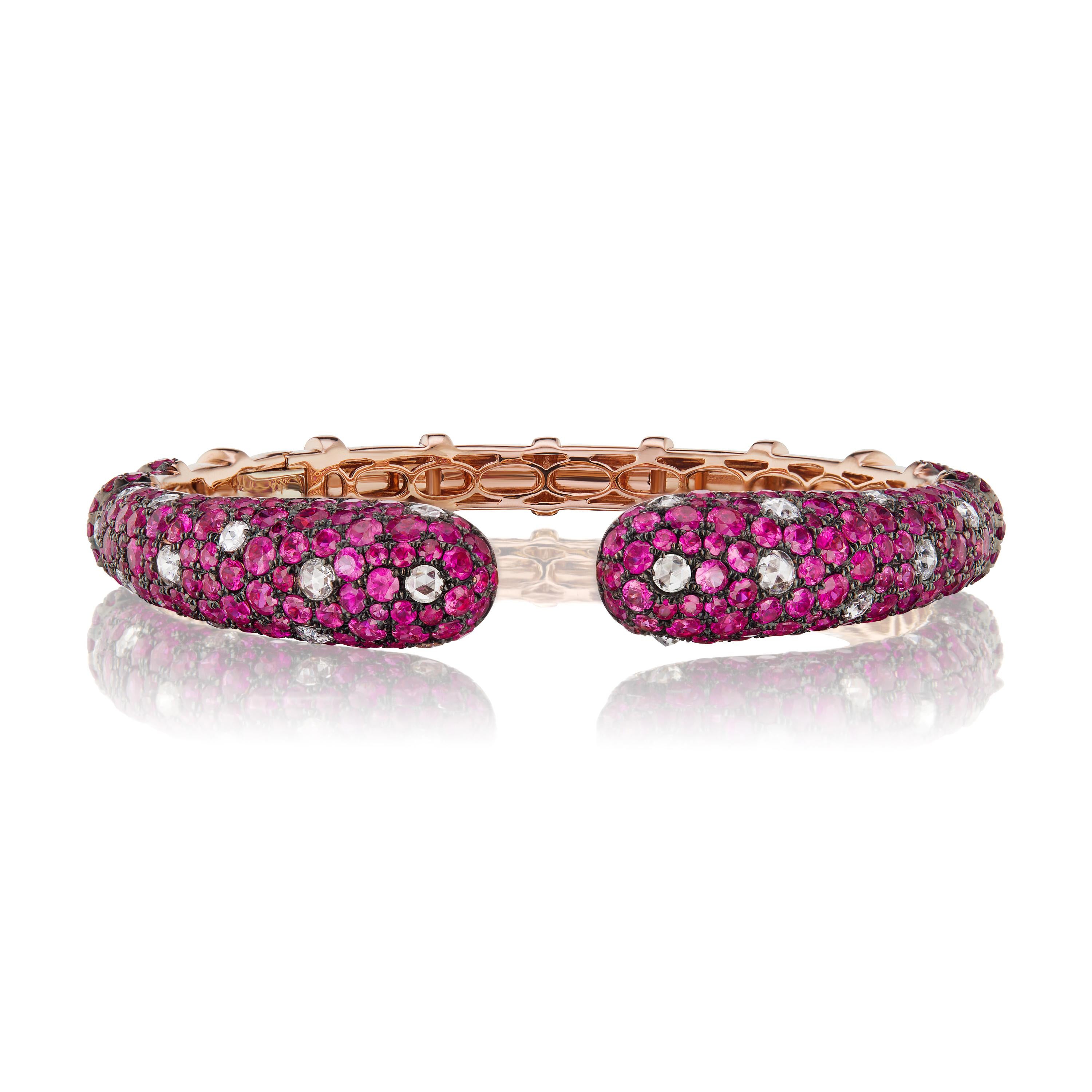 The Ruby cuff bangle has an immaculate look, crafted with 12.81 carats ruby and 1.45-carat round-rose cut diamonds on 18 karat rose gold by Nigaam. The cuff bangle is studded with prong set round rubies and diamonds. The diamonds are of G-H color