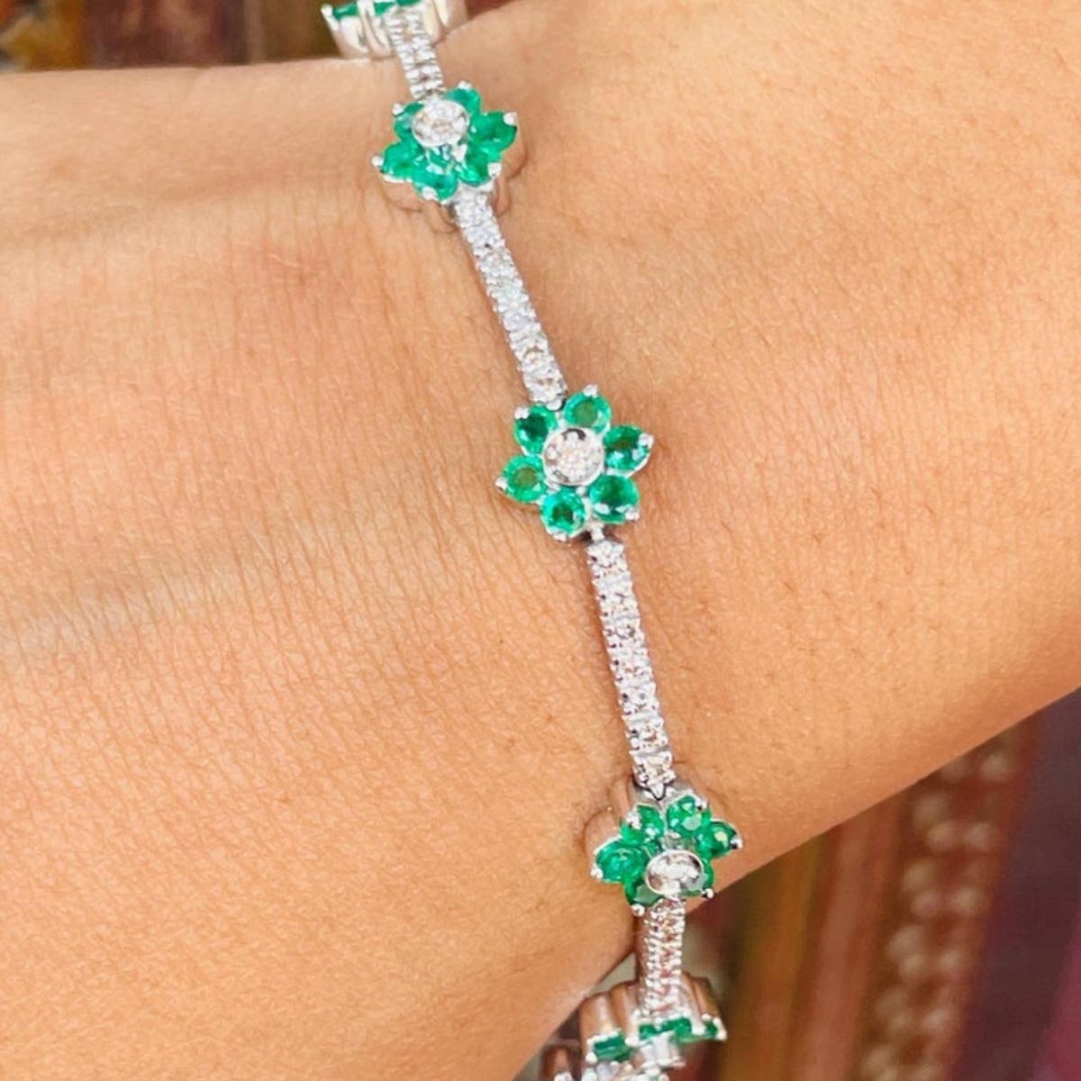 12.87 Ct Minimal Flower Bracelet in Natural Emerald and Diamond 18k White Gold showcases 60 endlessly sparkling natural emerald, weighing 12.87 carat and 80 pieces of diamonds weighing 1.09 carat. It measures 7.5 inches long in length. 
Emerald