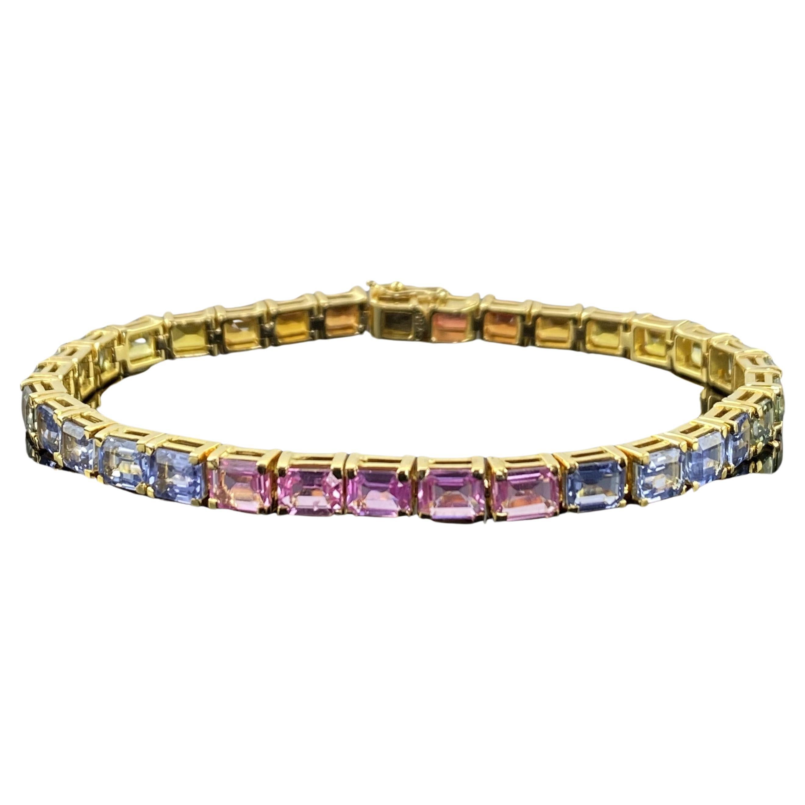 A beautiful 12.89 carat emerald cut multi colored sapphire tennis bracelet, set in 18.11 grams of solid 18K Yellow Gold. Currently the bracelet is 7 inches long, can be altered. 
Please feel free to message us for more information