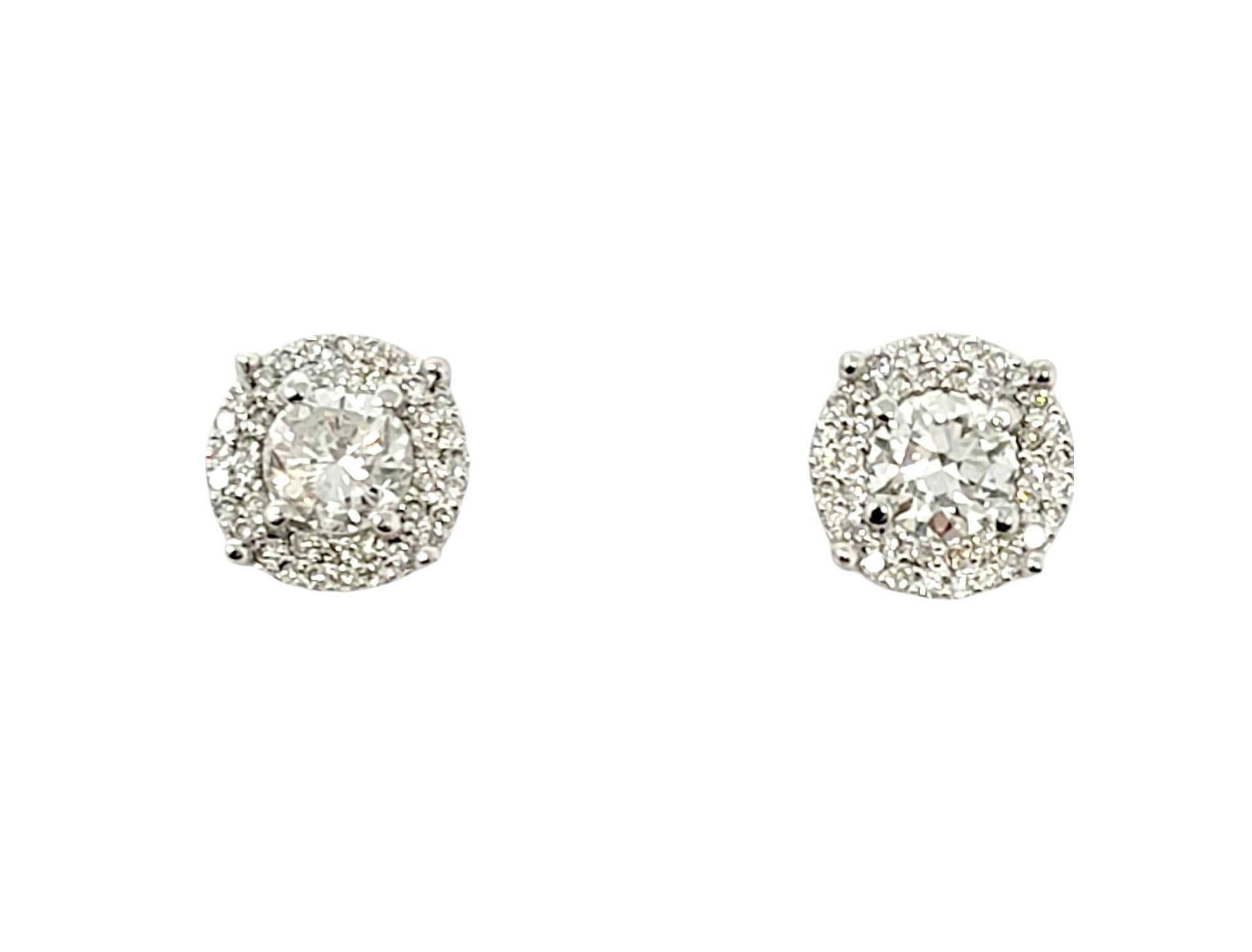 Beautiful, timeless diamond stud earrings with an elevated modern twist. They feature a single sparkling prong set center stone surrounded by a glittering halo of accent diamonds. The gorgeous pave diamond studs offer substantial sparkle and glamour