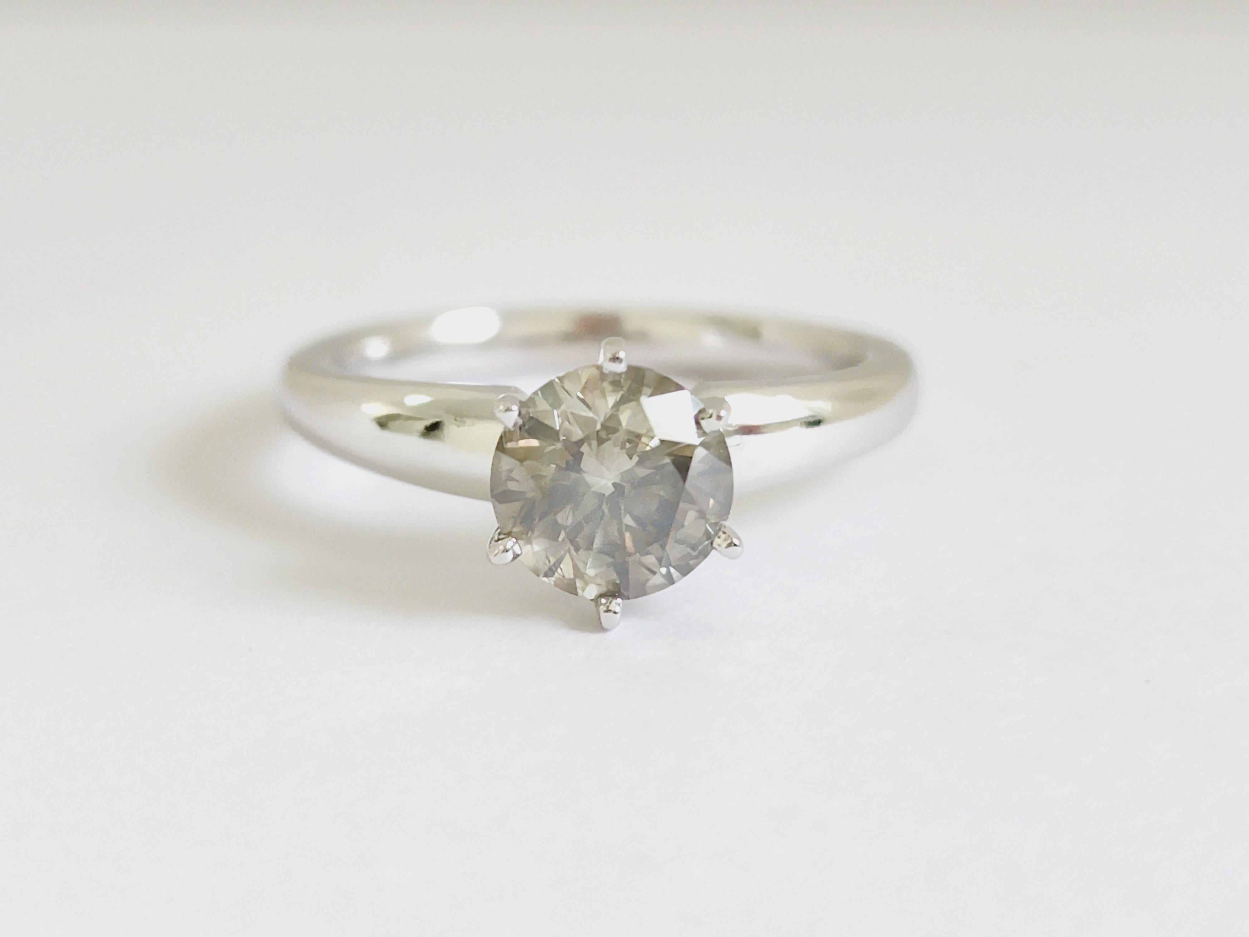 1.29 Carats round diamond set on a 6 prong white gold 14 Karat solitaire Ring. 
Natural Greenish Gray, I3
Ring Size 7 