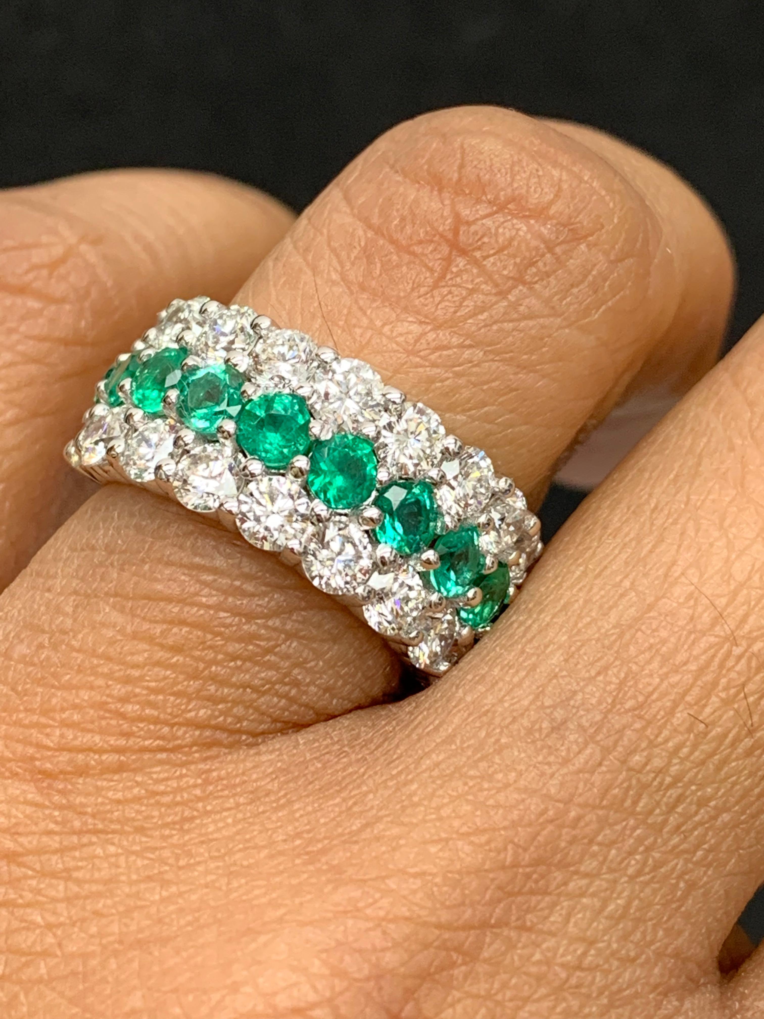 A unique and fashionable ring showcasing two rows of round-shape 18 diamonds and one row of 10 emeralds in the middle, set in a band design. Emeralds weigh 1.29 carats and Diamonds weigh 2.70 carats total. A brilliant and masterfully-made