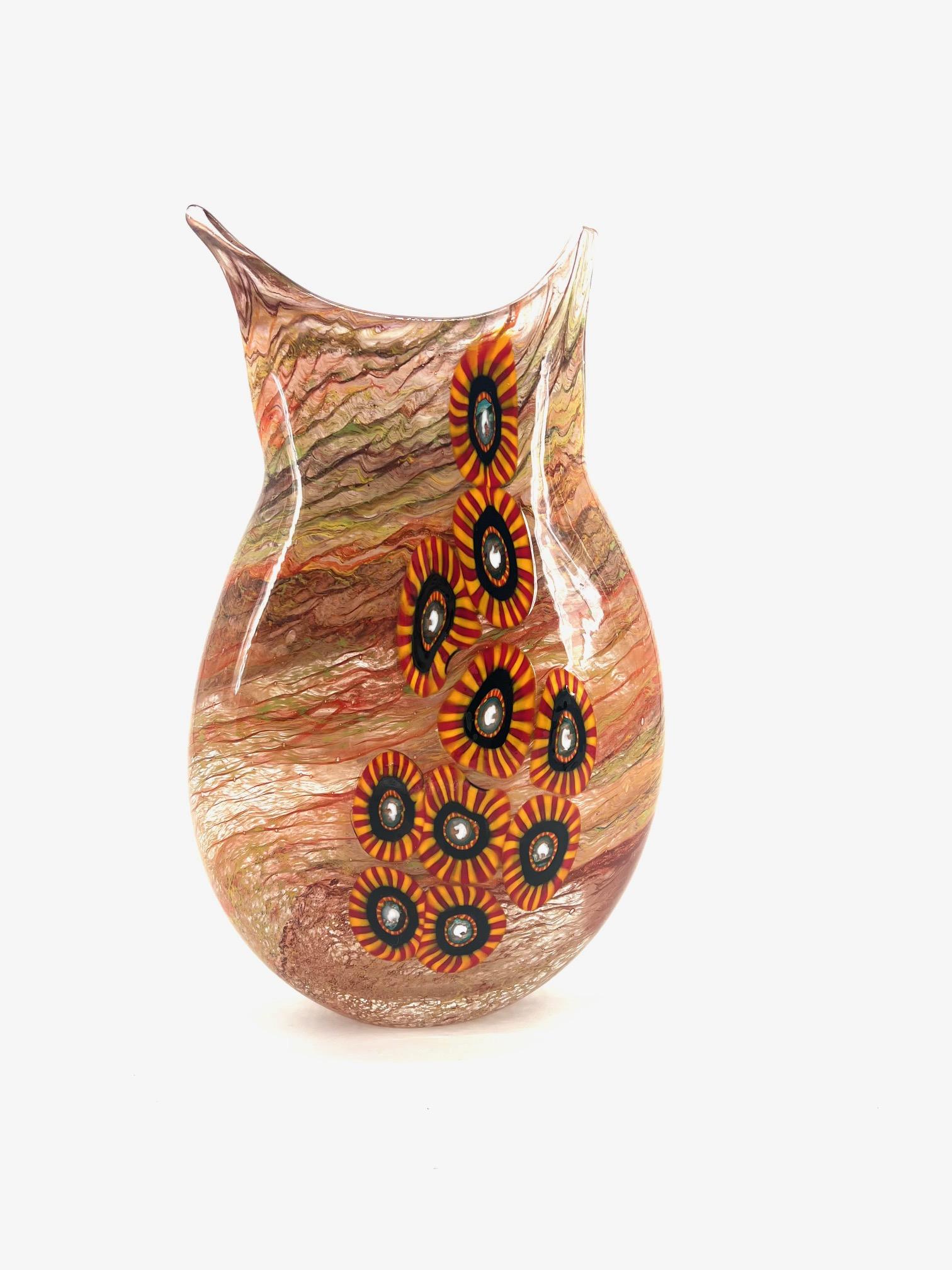 Our aim is the emotion through the creation of murano glass artpieces. 
 
This art-vase is hand made in our murano workshop, our master blowns glass in multicolour nouances and Medallions Murrine to gives to the artpiece nice colours and