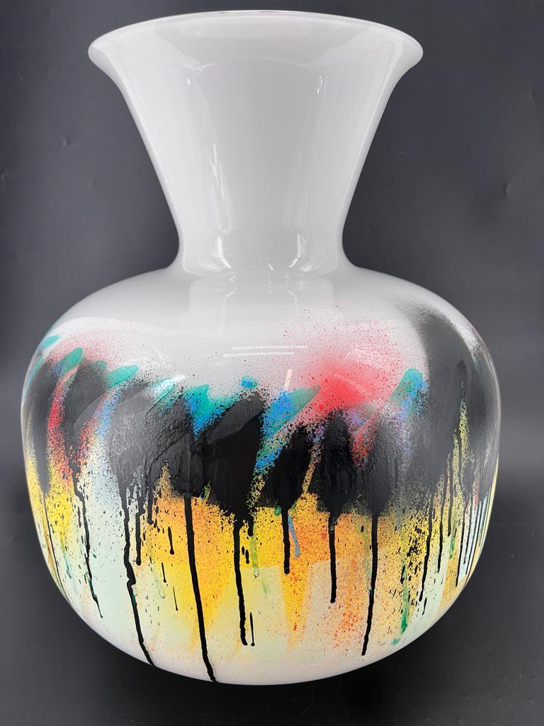 A  one-of-a-kind  Art Vase:

This unique and exceptional vase is made by hand in the renowned glass furnaces of Venice, 1295Murano, A series of art-pieces hand made in collaboration with Street Artists. 
It is a large, milky white blown glass vase,