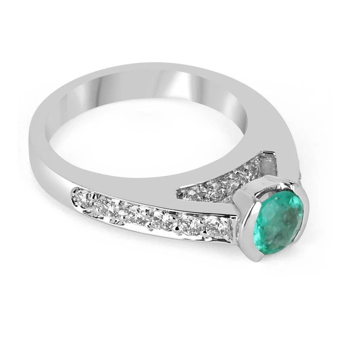 Elegantly displayed is a round shape Colombian emerald and diamond accent engagement ring. The center gem is filled with life and brilliance! Among the emeralds, impressive qualities are its vibrant color and beautiful eye clarity. This gemstone is