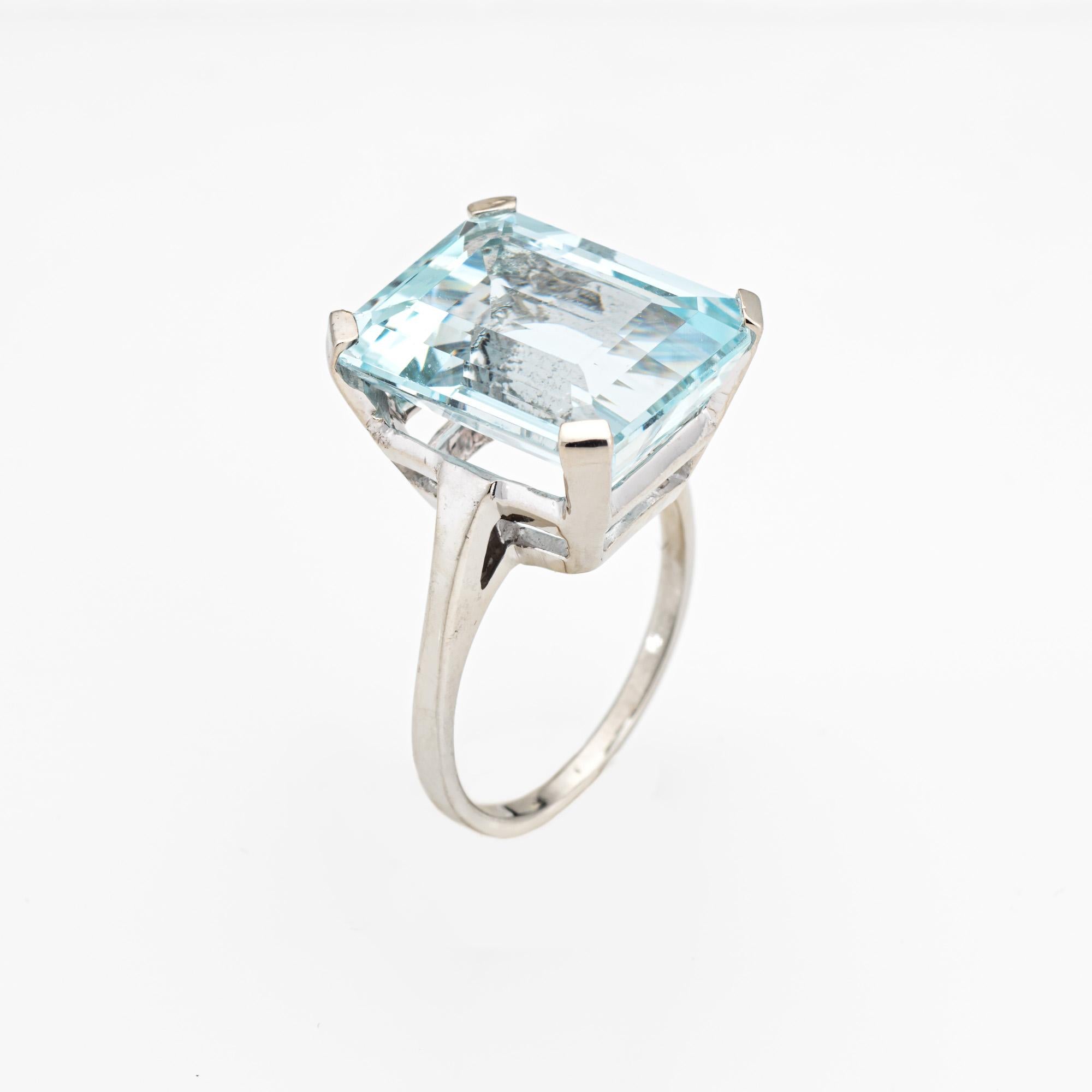 Stylish vintage aquamarine cocktail ring (circa 1960s to 1970s) crafted in 14k white gold. 

Emerald cut aquamarine measures 16mm x 12.5mm (estimated at 12 carats). The aquamarine is in good (few tiny flea bite chips visible under a 10x loupe).