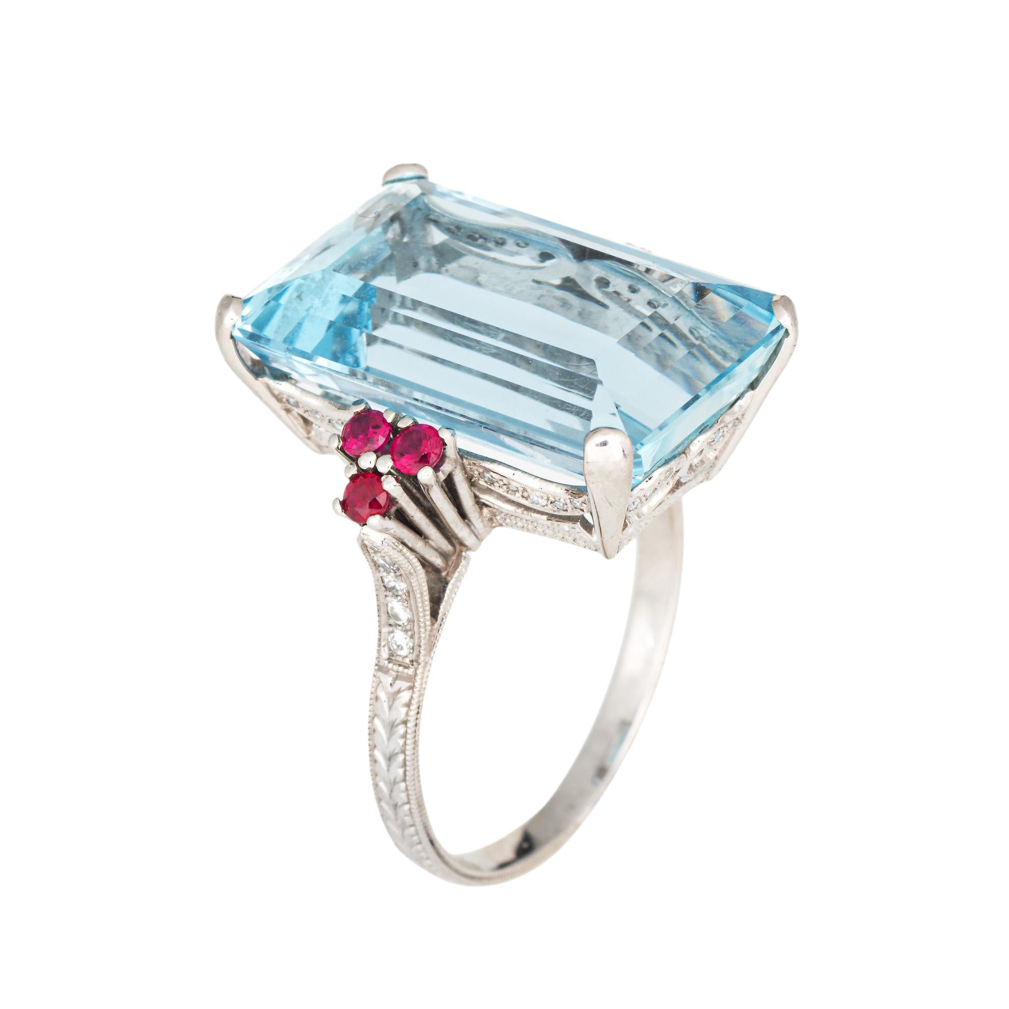 Elegante anello cocktail con acquamarina e rubino di proprietà, realizzato in platino 900. 

L'acquamarina taglio smeraldo misura 19 mm x 12 mm (stima 12 carati). Il rubino misura circa 2 mm. I diamanti ammontano a circa 0,20 carati (colore I-J e