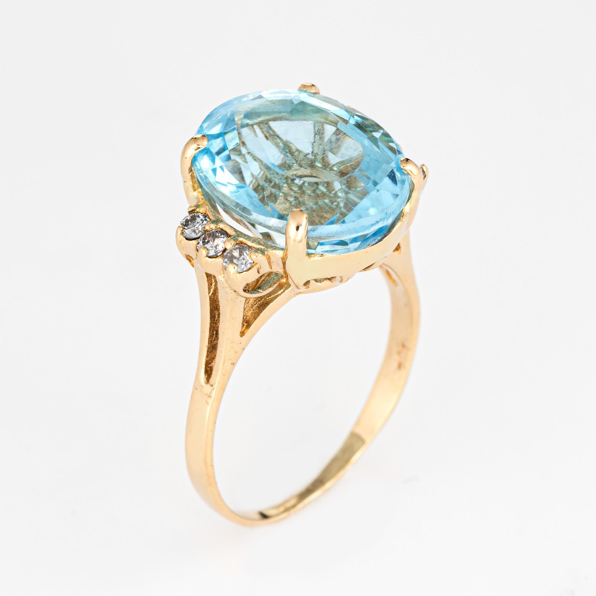 Stylish vintage blue topaz & diamond cocktail ring (circa 1980s to 1990s) crafted in 14 karat yellow gold. 

Oval faceted blue topaz measures 14mm x 12mm (estimated at 12 carats), accented with an estimated 0.12 carats of diamonds (estimated at H-I