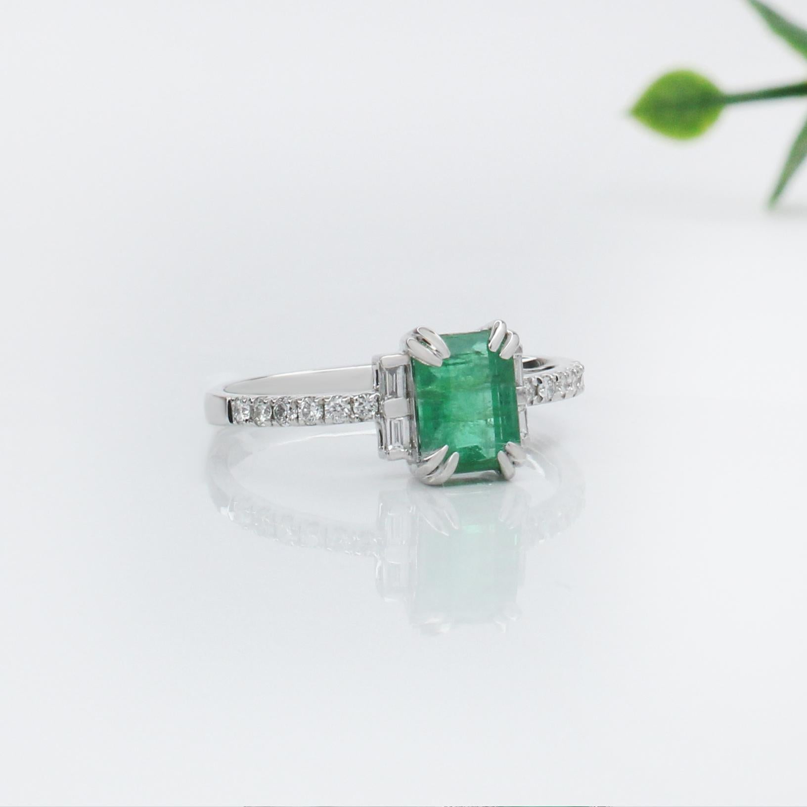 This exquisite ring features a 1.22 carat emerald-cut Emerald, elegantly set in solid 14K gold. The band is adorned with a series of sparkling natural earth mined diamonds, adding a touch of brilliance and sophistication. The combination of the