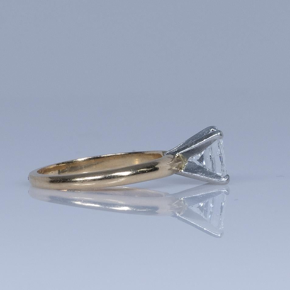 This stunning engagement ring features a 1.2 carat princess-cut diamond, set in 14k yellow gold. The diamond's brilliant facets and sharp angles catch the light beautifully, creating a captivating sparkle. The classic solitaire setting highlights