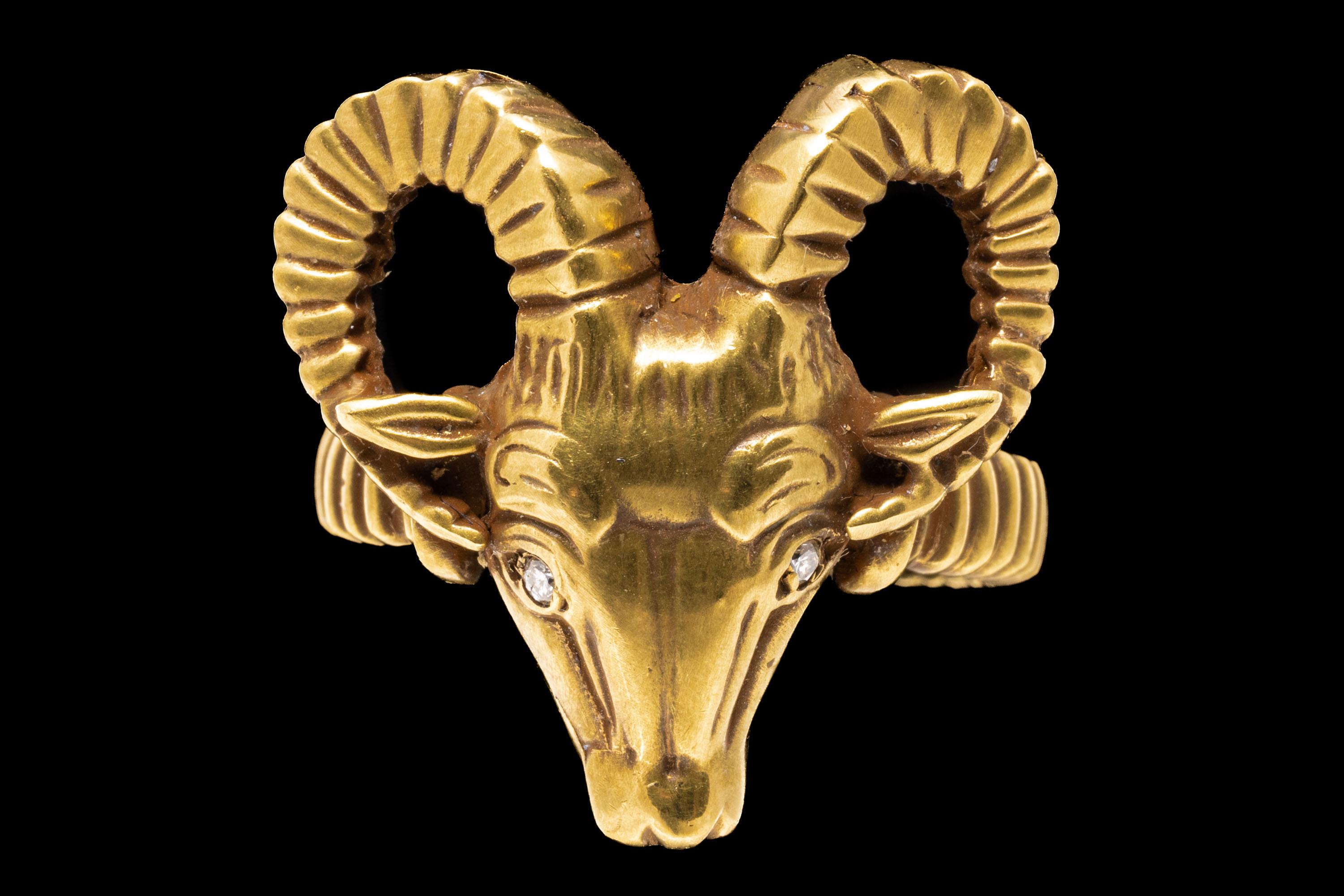 ring aus 2k Gelbgold. Dieser eindrucksvolle Ring aus brüniertem Gelbgold hat in der Mitte einen figuralen Widderkopf mit gerippten Hörnern und runden, facettierten Diamanten als Augen, etwa 0,02 TCW. Der Ring ist mit gerippten Schultern und Schäften