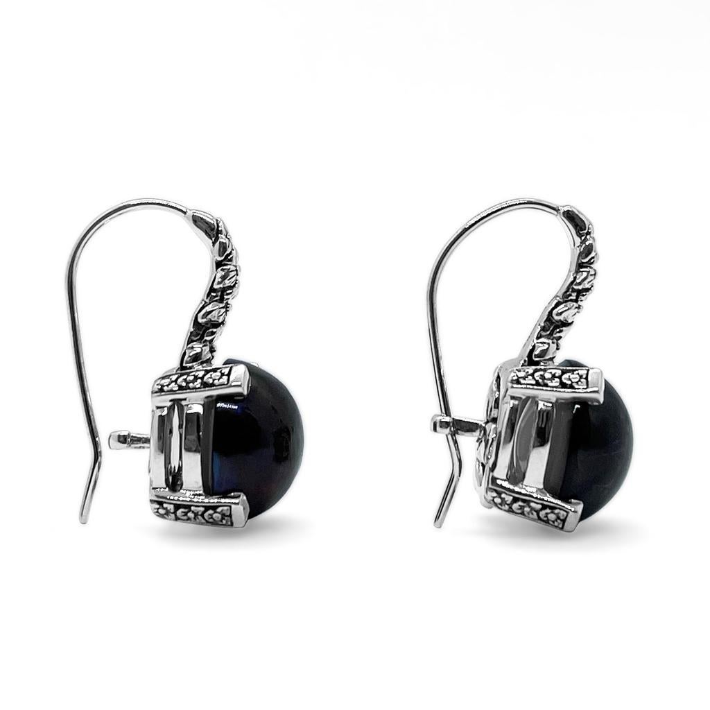 12mm Black Mabe Earring in Engraved Sterling Silver

Stephen’s heart and passion go into each Dweck design, as the placement of each stone and its connection to nature has meaning. While bold and opulent, his jewelry has a weightless elegance for