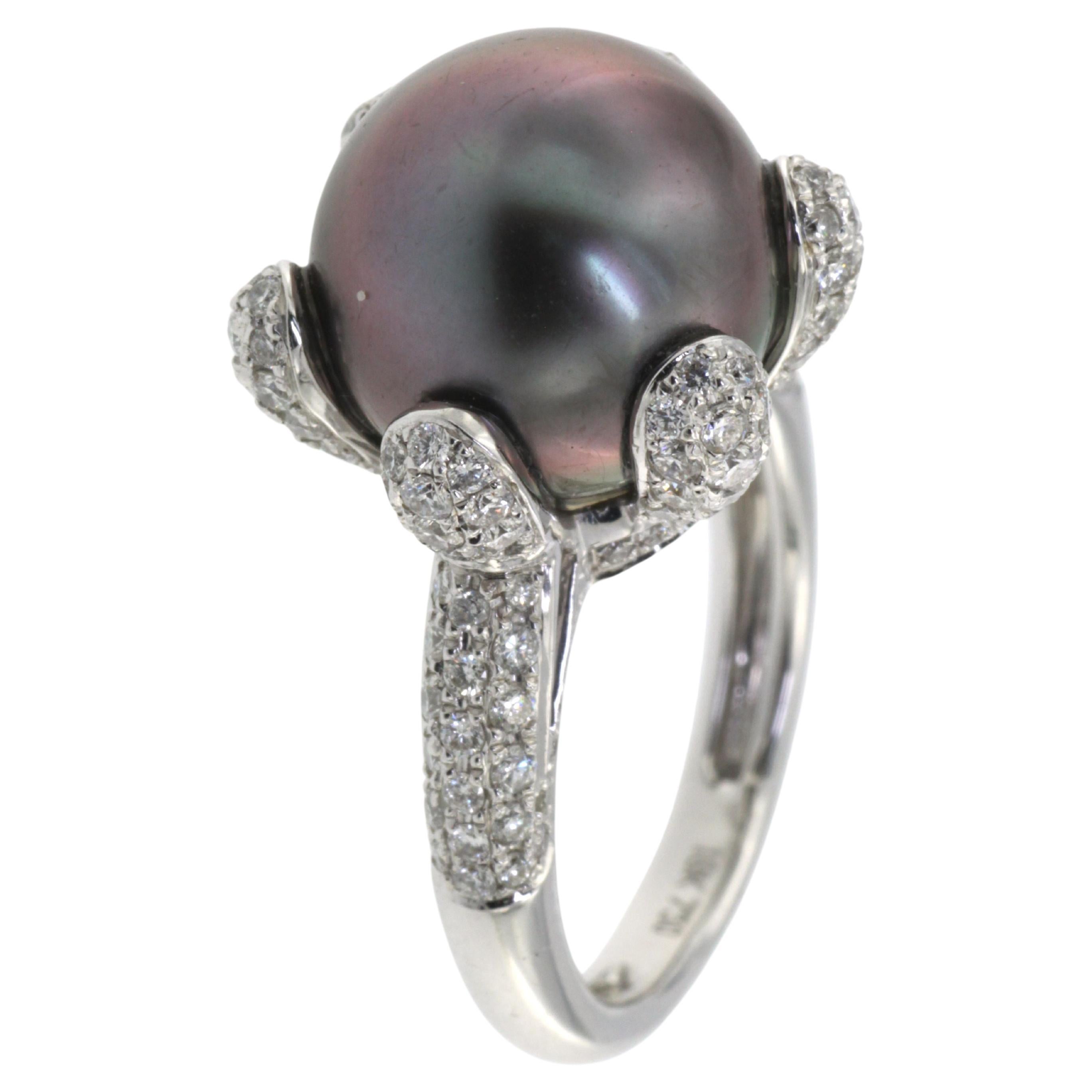 Experience luxury at your fingertips with this magnificent ring. At its heart lies a captivating 12mm Tahitian black pearl, radiating an enigmatic luster that beckons admiration. Elegantly encircling this majestic gem are 1.24 carats of white round