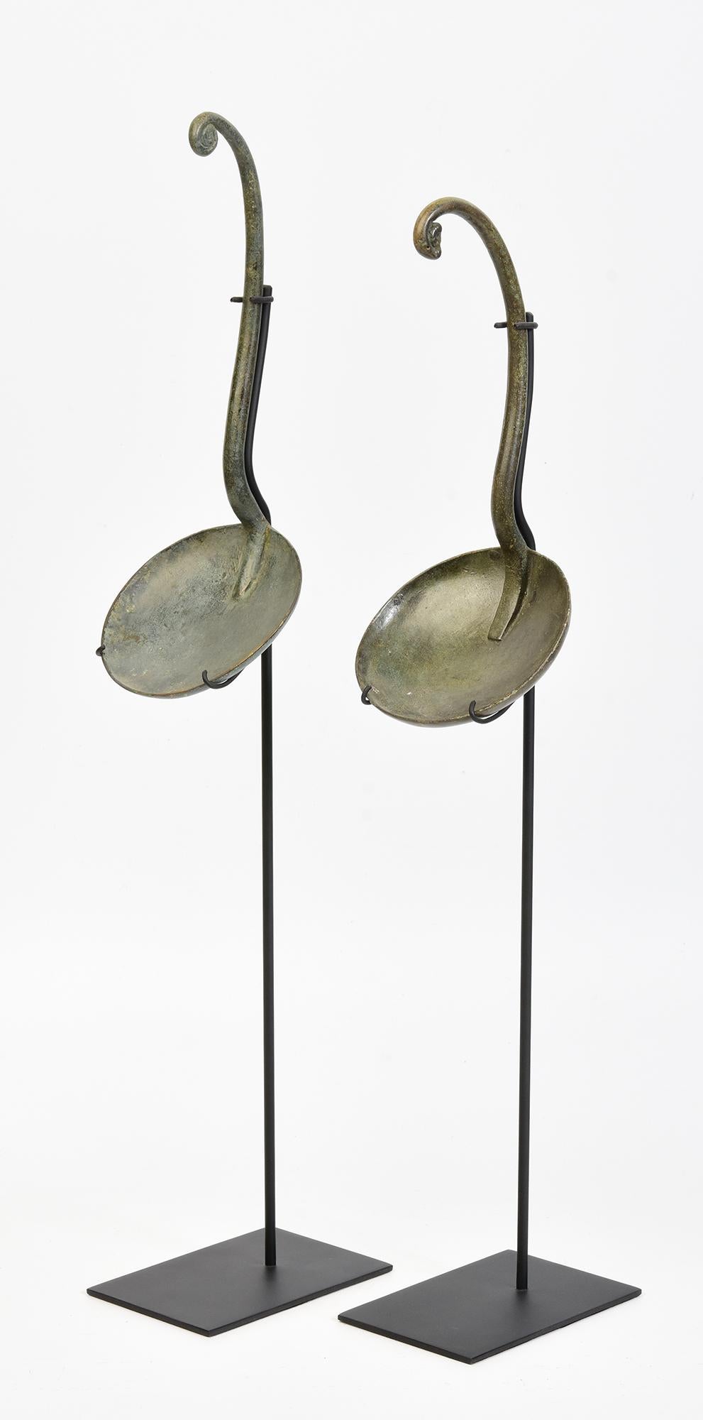 A pair of antique Khmer bronze ritual ladle spoon for holy water with stand.

Age: Cambodia, Angkor Vat Period, 12th Century
Size of each ladle: Length 21.1 - 23.8 C.M. / Width 9.2 - 9.5 C.M.
Size including stand: Height 47.3 - 50.5 C.M.
Condition: