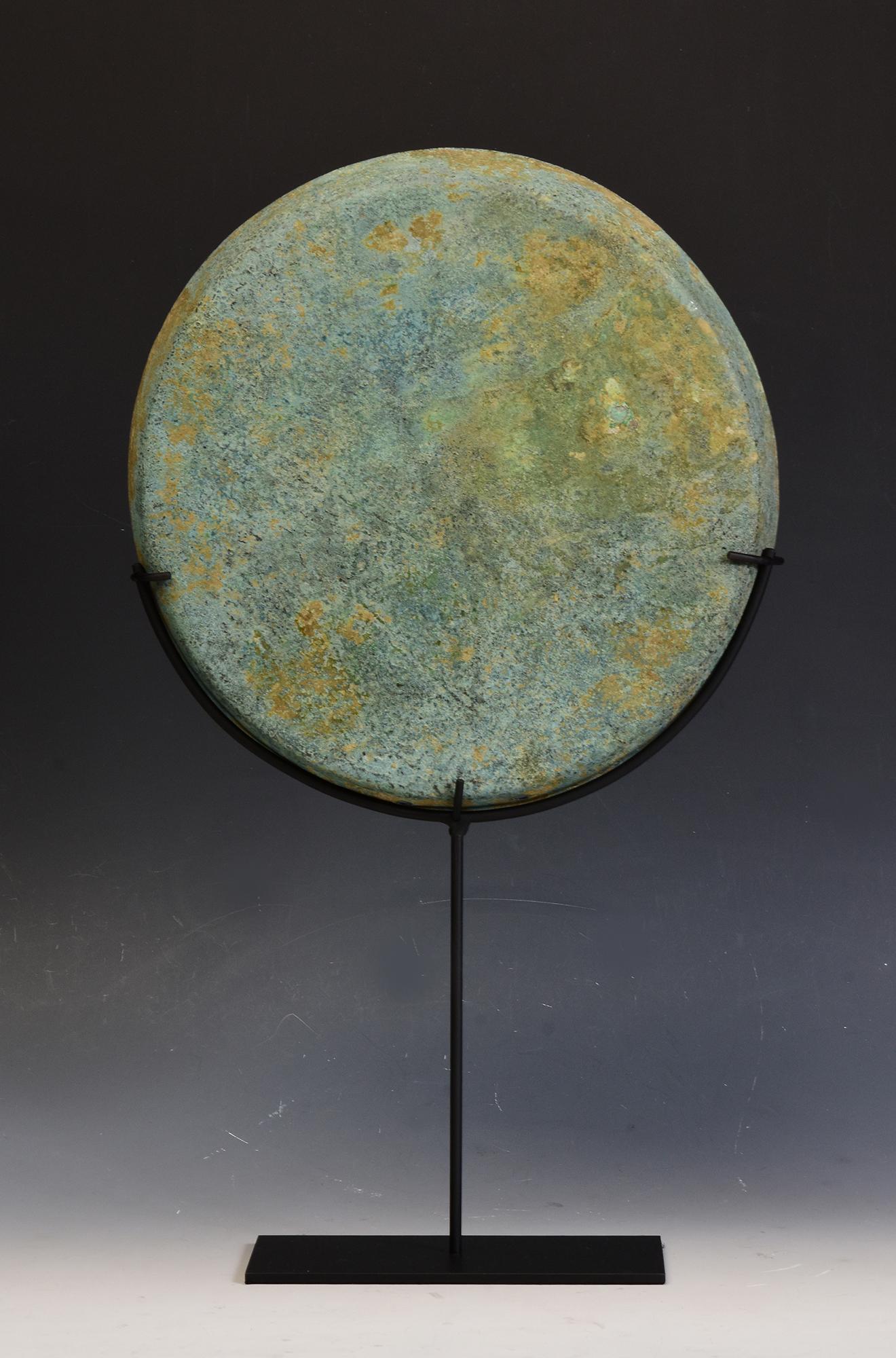 Antique Khmer bronze gong with nice green patina with stand.

Age: Cambodia, Angkor Vat Period, 12th Century
Size of gong only: Diameter 26.6 C.M. / Thickness 3 C.M.
Size including stand: Height 46 C.M.
Condition: Nice condition overall (some