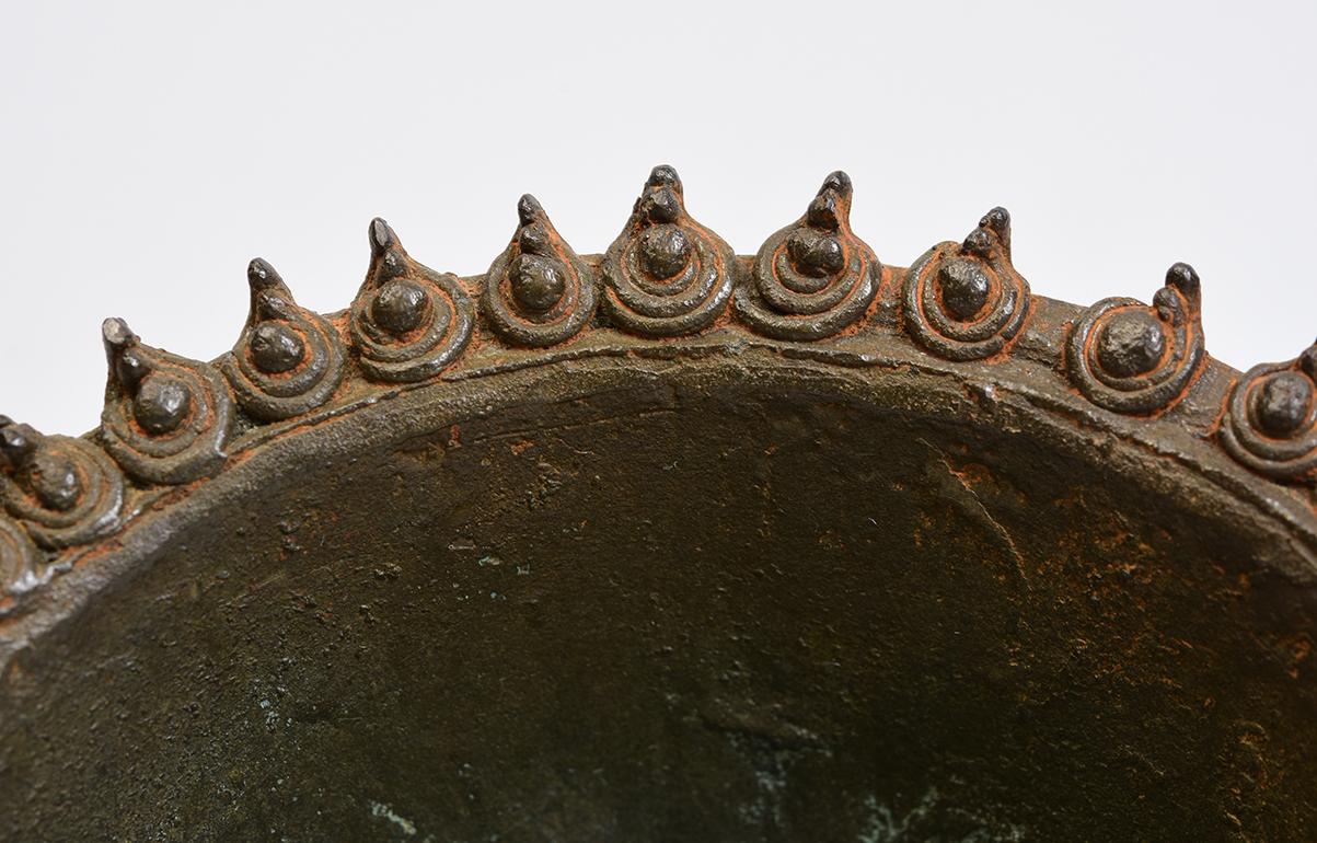 Khmer bronze ladle for holy water with Rahu on the handle.

Age: Cambodia, Angkor Vat Period, 12th Century
Size: length 21.6 cm. / diameter 11.2 cm.
Size including stand: height 23.4 cm
Condition: Nice condition overall (some expected