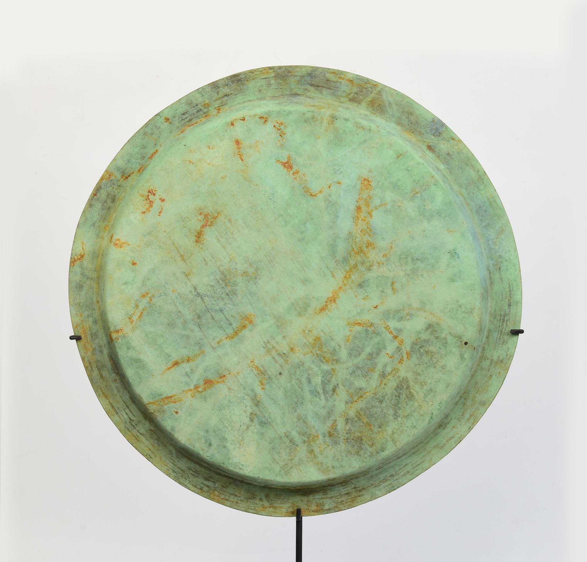 Antique Khmer bronze tray with beautiful green patina with stand.

Age: Cambodia, Angkor Vat Period, 12th Century
Size of tray only: Diameter 32.5 C.M.
Height including stand: 52.5 C.M.
Condition: Nice condition overall (some expected degradation