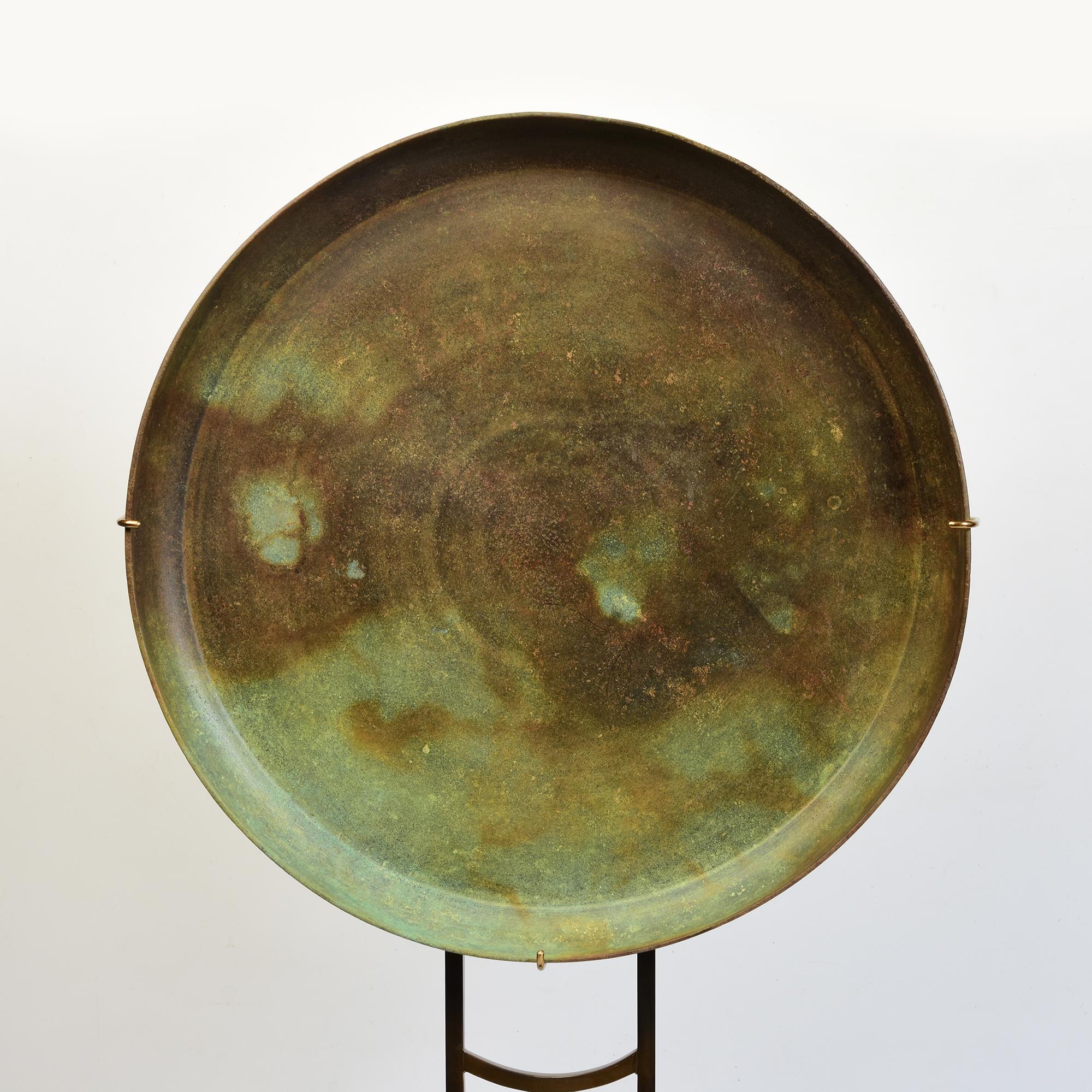 Antique Khmer bronze tray with nice green patina with stand.

Age: Cambodia, Angkor Vat Period, 12th Century
Size of tray only: Diameter 35.1 C.M. / Thickness 3.2 C.M.
Height including stand: 68 C.M.
Condition: Nice condition overall (some expected