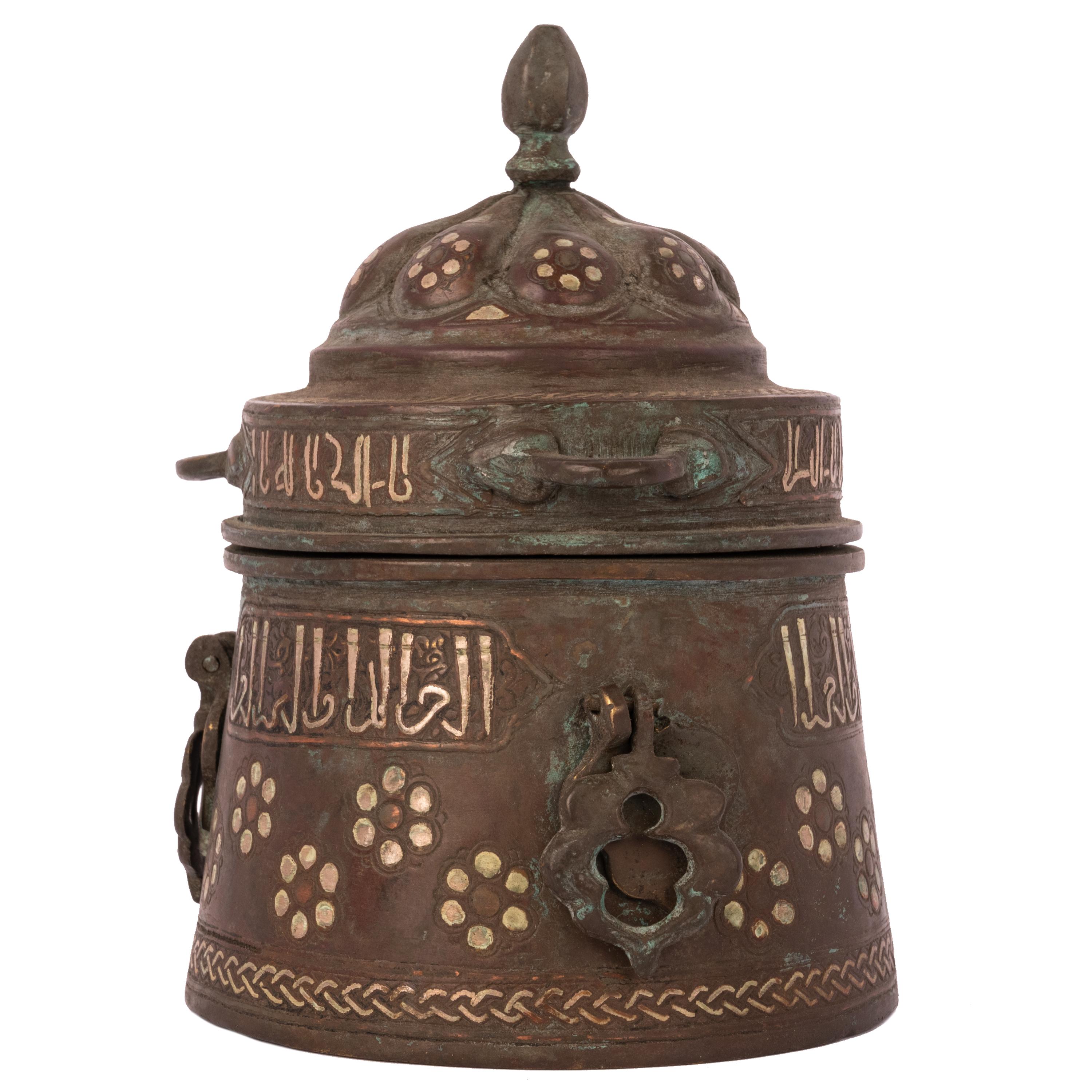An ancient Khurasan silver and copper inlaid bronze inkwell, Eastern Persia or Herat, 12th-13th century, from an important private Middle East collection.
The inkwell is of cylindrical shape with a domed shaped lid with dot shaped silver and copper