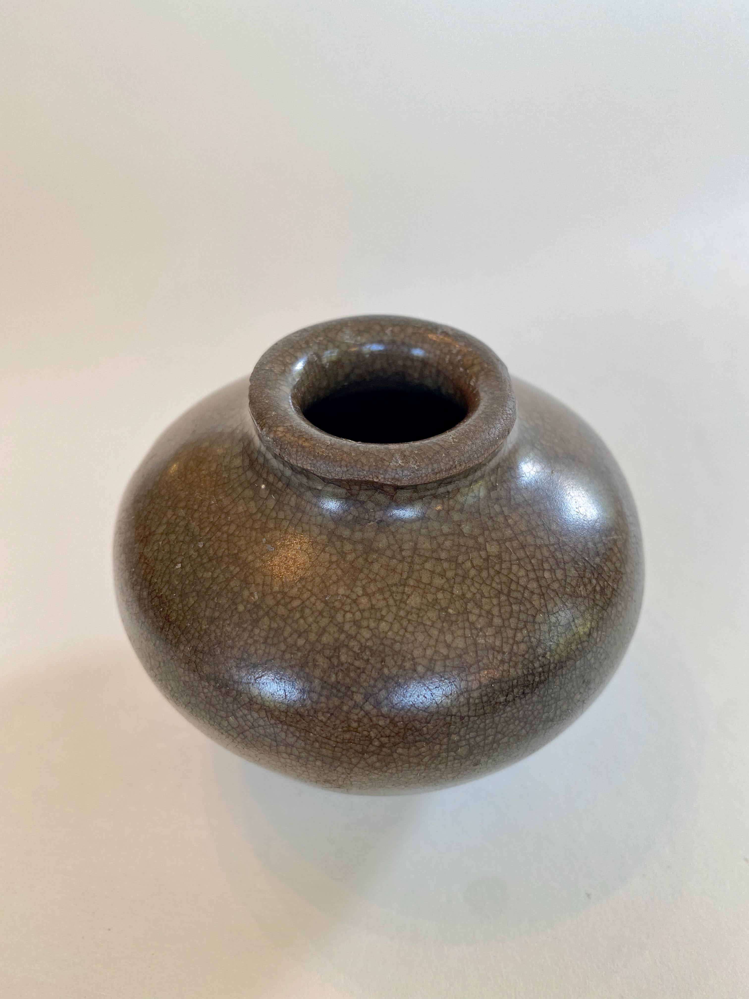 Song jarlet with deep brown glaze, 12th century. 

This small piece is all about purity of form, enhanced by the rich color of its glaze, which has a subtle crackle. The glaze, which covers almost the entire piece except for the very edge of its