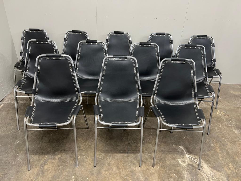 Non troverai un altro set di 12 sedie in pelle nera come questo su nessun sito web al mondo! Di Charlotte Perriand per la stazione sciistica di Les Arcs, circa 1960. Struttura tubolare cromata molto bella con sedili in pelle nera spessa che sono