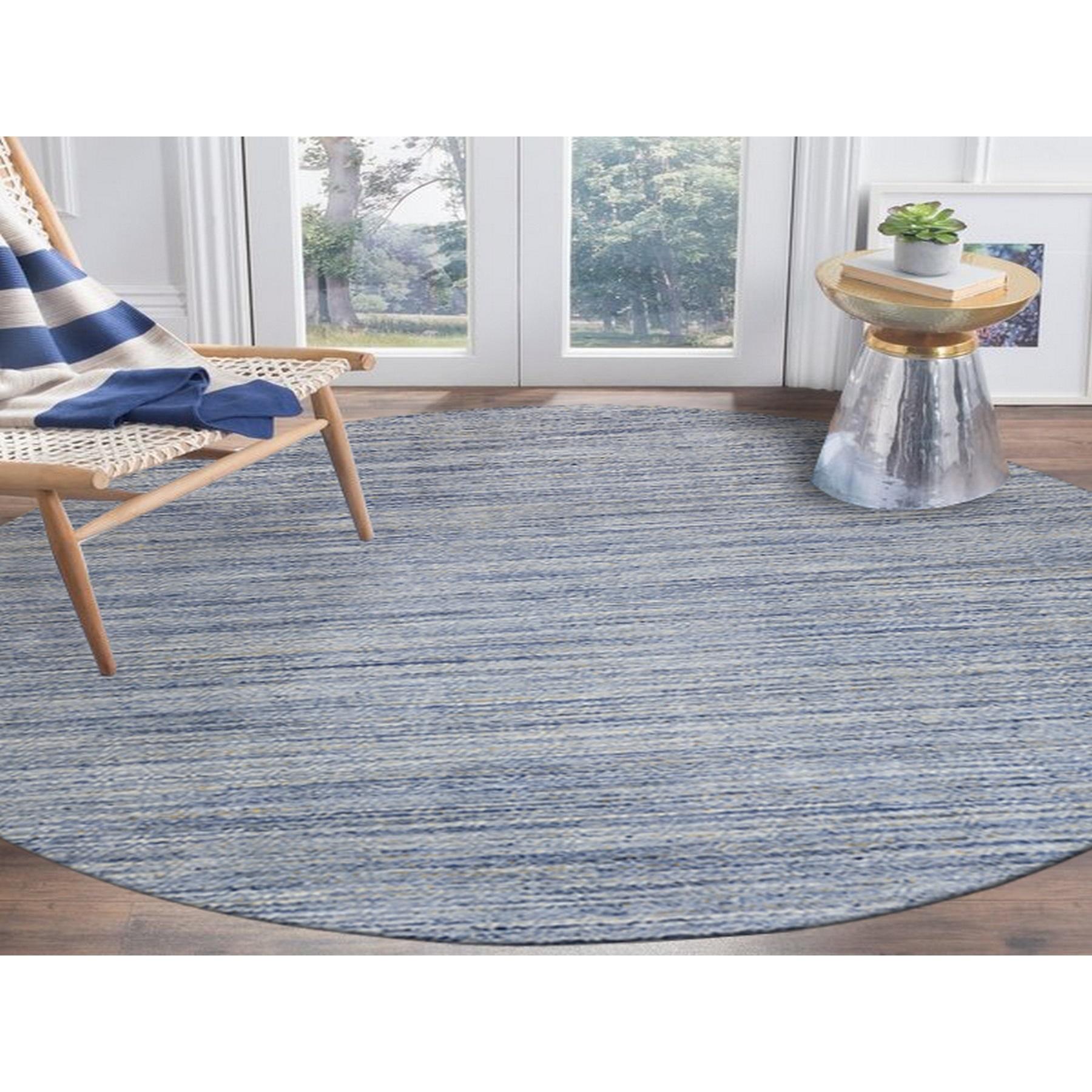 Il s'agit d'un véritable tapis rond oriental transitionnel en laine organique, tissé à la main en bleu argenté avec un design à texture variée. Il a été tissé pendant des mois et des mois selon des techniques artisanales séculaires par des artisans