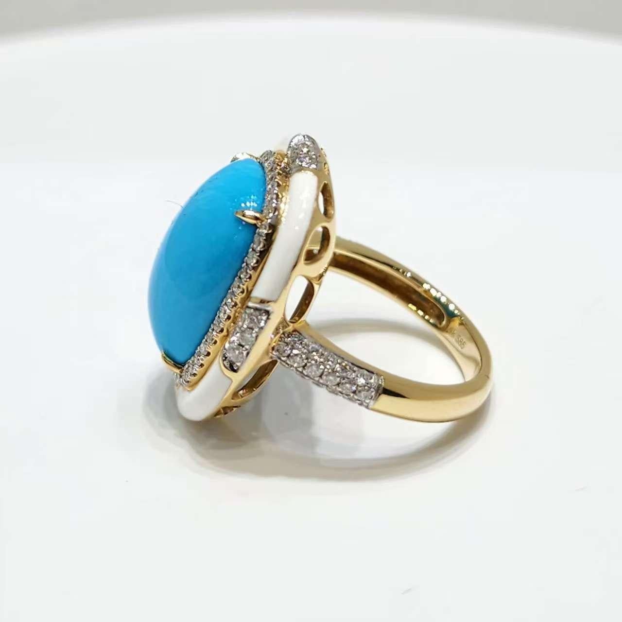 Cette bague exquise est un mélange captivant d'élégance et de design moderne, réalisée en or jaune 14 carats. La pièce centrale présente un magnifique cabochon ovale de turquoise de 12 x 16 mm, dont la couleur bleue sereine rayonne de tranquillité