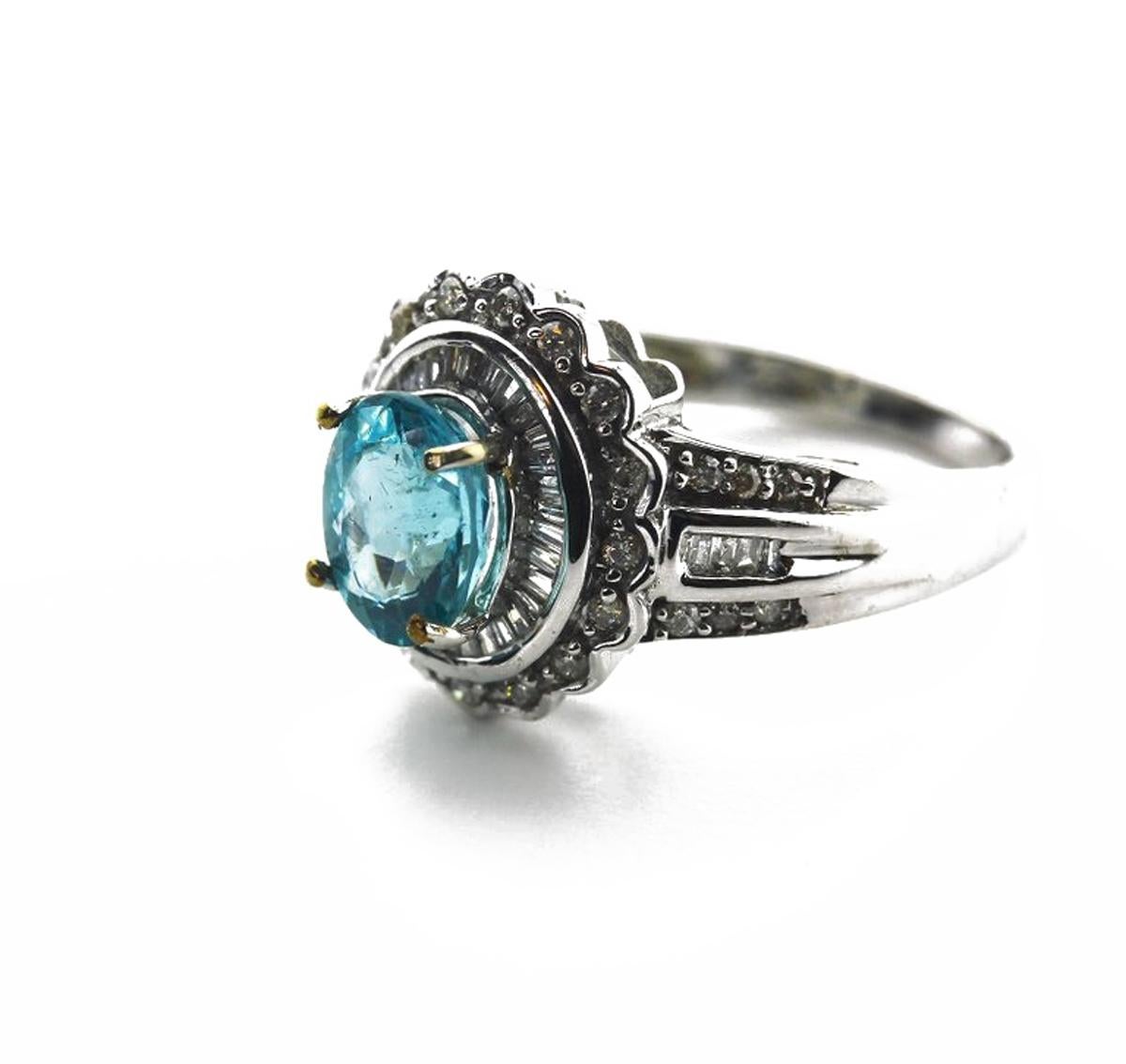Glittering 1.3 Carat bright blue Apatite is enhanced with brilliant glittering little white Diamonds and set in a handmade unique 10KT white gold ring size 6 (sizable),  