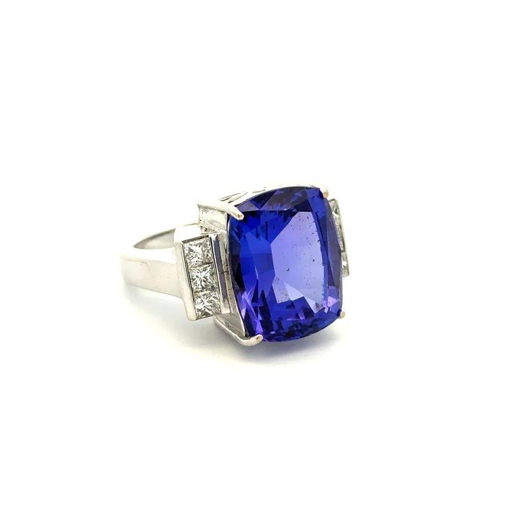 Simply Beautiful! Tanzanite and Diamond Oscar Worthy Vintage Cocktail Ring. Centering a 13 Carat Cushion Tanzanite, accented either side by Princess Diamonds, weighing approx. 1.20tcw. Hand crafted 18K White Gold mounting. Approx. Dimensions: 1.2” l