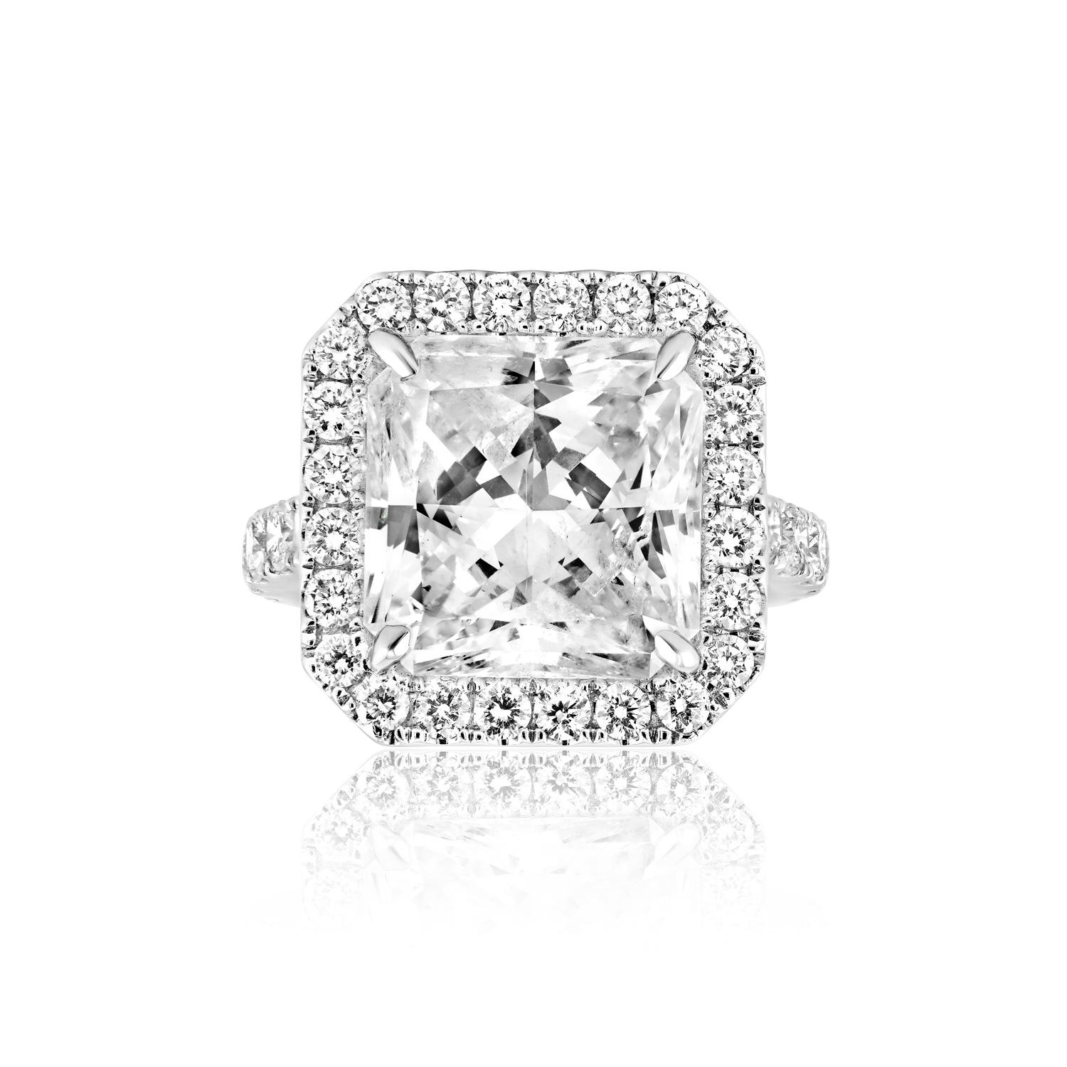 
Center Diamond:

Carat Weight: 10.45 Carats
Style: Radiant Cut - Feather Filled- Special Care Required 

Ring:
Setting: Halo, Sidestone & 4 Round Prong
Metal: 18 Karat White Gold 8.80 Grams
Style: Round Brilliant Cut 
Carat Weight: 2.05