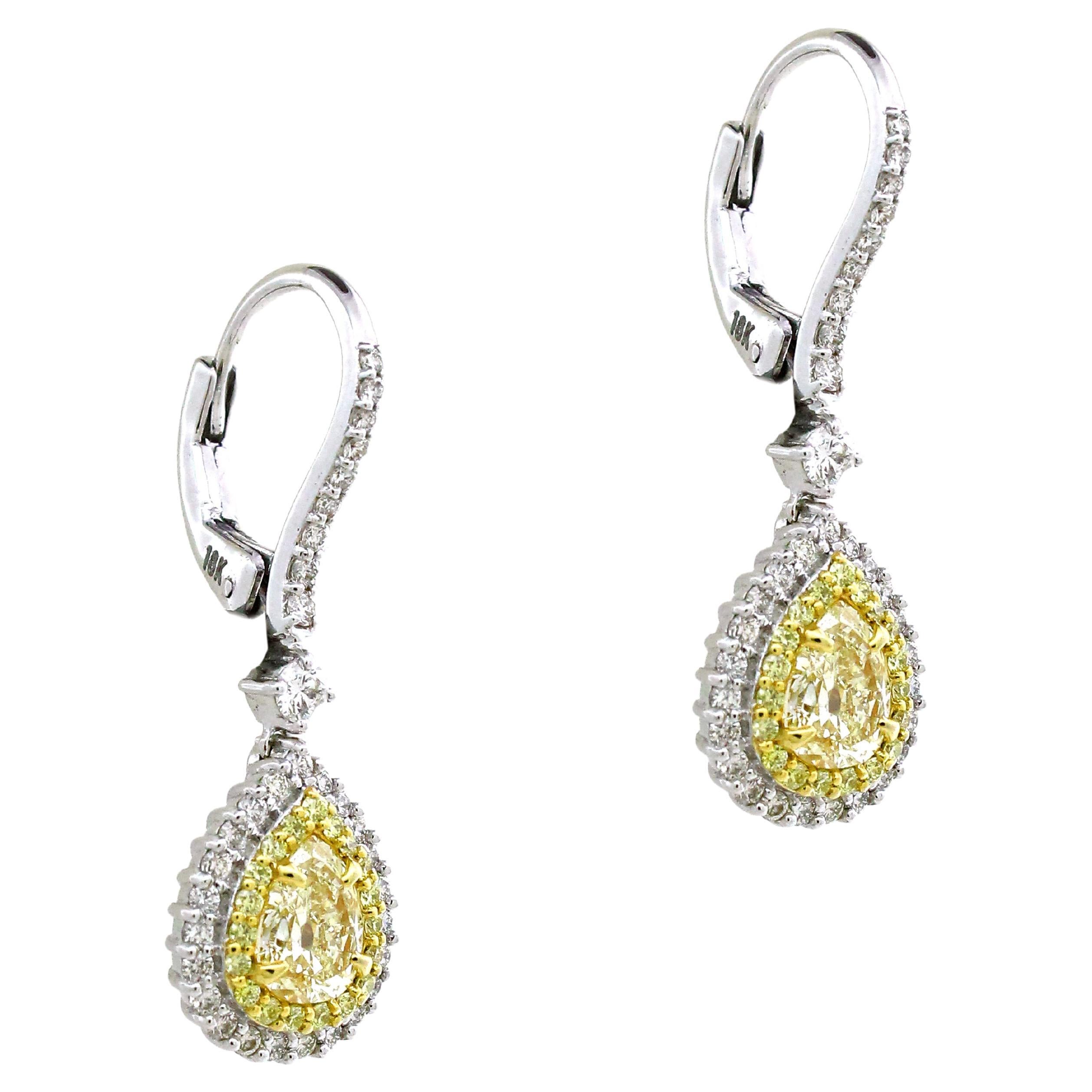 Indulge in opulent luxury with these exquisite earrings that redefine elegance. Adorning your ears, the centerpiece of each earring boasts a luminous yellow pear-cut diamond, weighing a sumptuous 1.3 carats. 
A captivating halo of 39 yellow round