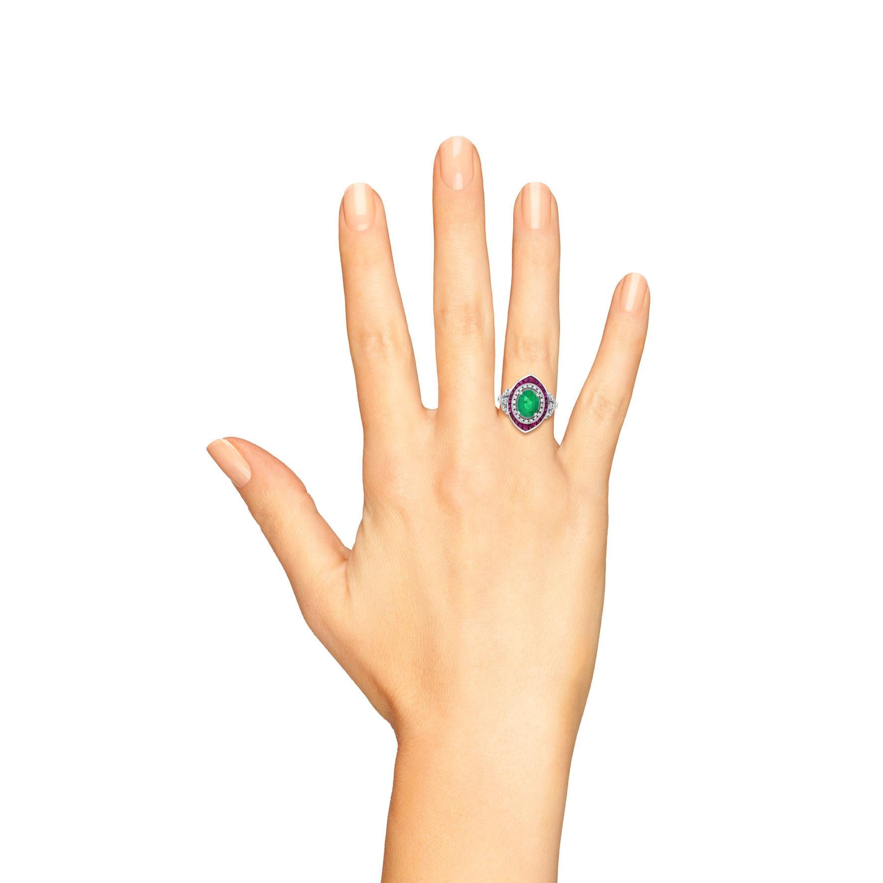 The Emerald, Ruby, and Diamond Art Deco Style Floral Shoulder Ring showcases a stunning 1.3 carat emerald at the center, surrounded by rubies that complement its rich green hue. The diamonds on the shoulders add a delicate touch of sparkle,