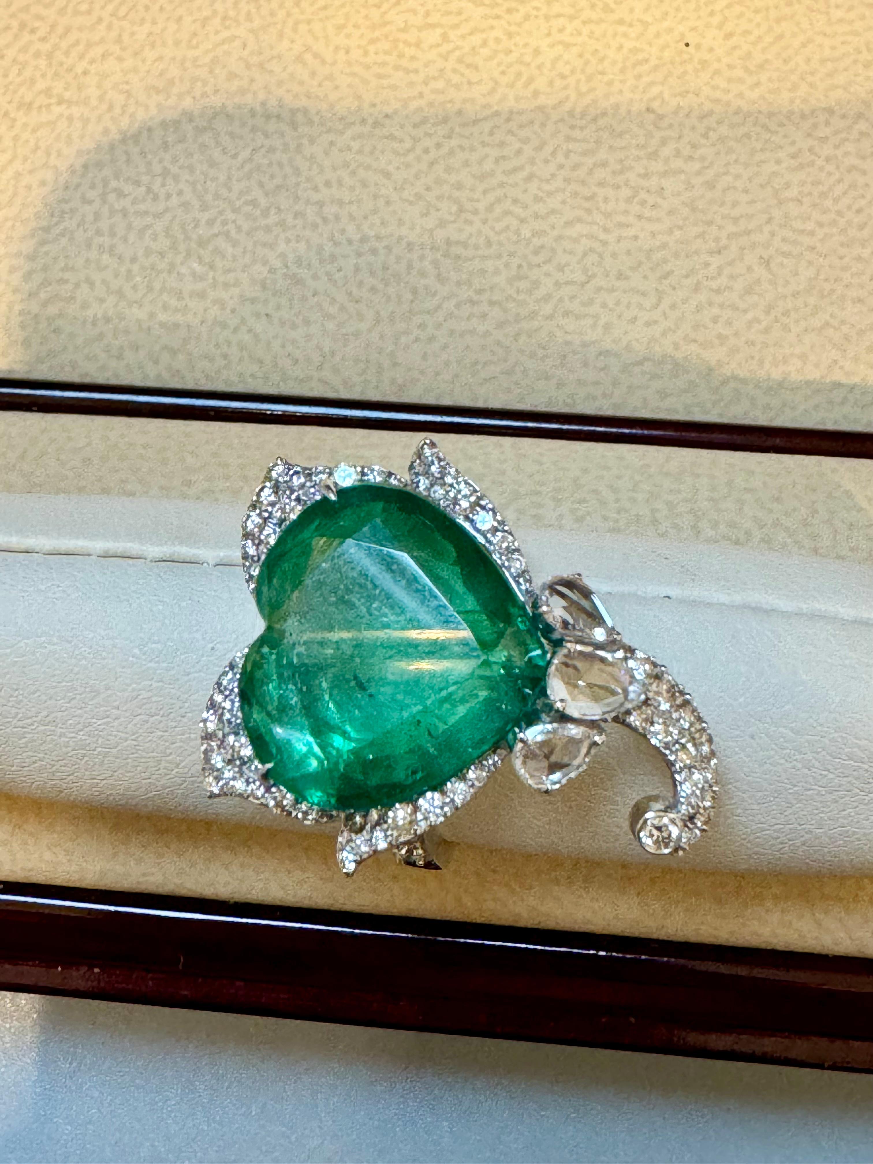 13 Ct  Zambian Heart Cut Emerald & 1.5 Ct Diamond Ring, 18 Kt Gold Size 8.5 
 This classic ring features a Heart cut Zambian emerald of extreme fine quality, boasting a desirable color and luster, originating from Zambia. Accompanied by many  rose