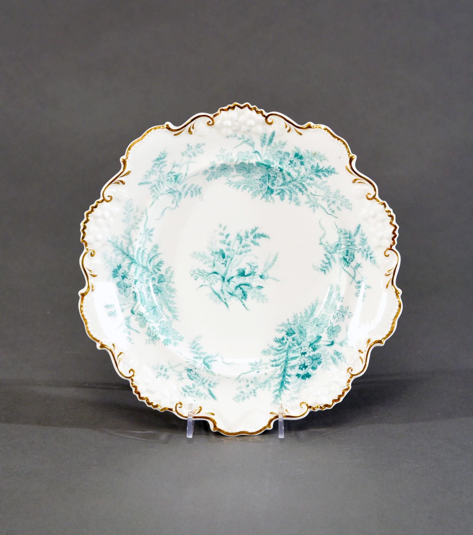 This set of 13 Aesthetic Movement dessert plates with matching serving compote, were made by Davenport ca. 1890's and feature hand decorated ferns surrounding the molded floral relief borders and highlighted with fern leaves. The soft blue-green