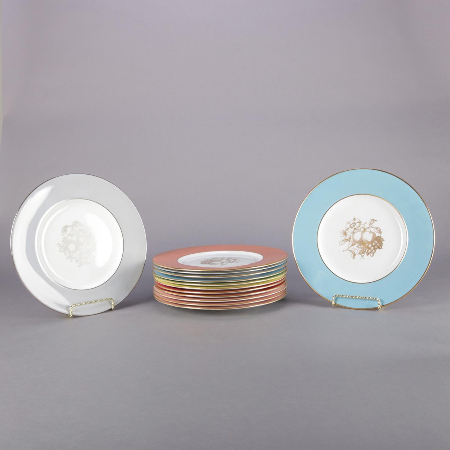Set of 13 English porcelain dinner plates by Spode feature multi colored rims in pastel palette with gilt trim (all gold gilt except grey rims with silver gilt) and central fruit and floral motif, en verso 