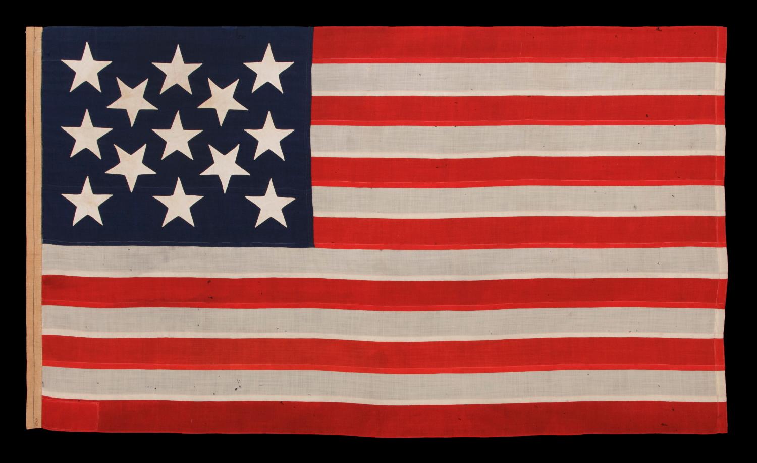 13 STAR ANTIQUE AMERICAN FLAG, A U.S. NAVY SMALL BOAT ENSIGN WITH ENORMOUS HAND-SEWN STARS, IN A REMARKABLE STATE OF PRESERVATION, CIRCA 1890-1899:

Despite the fact that America hasn't been comprised of 13 states since 1791, 13 star flags have been