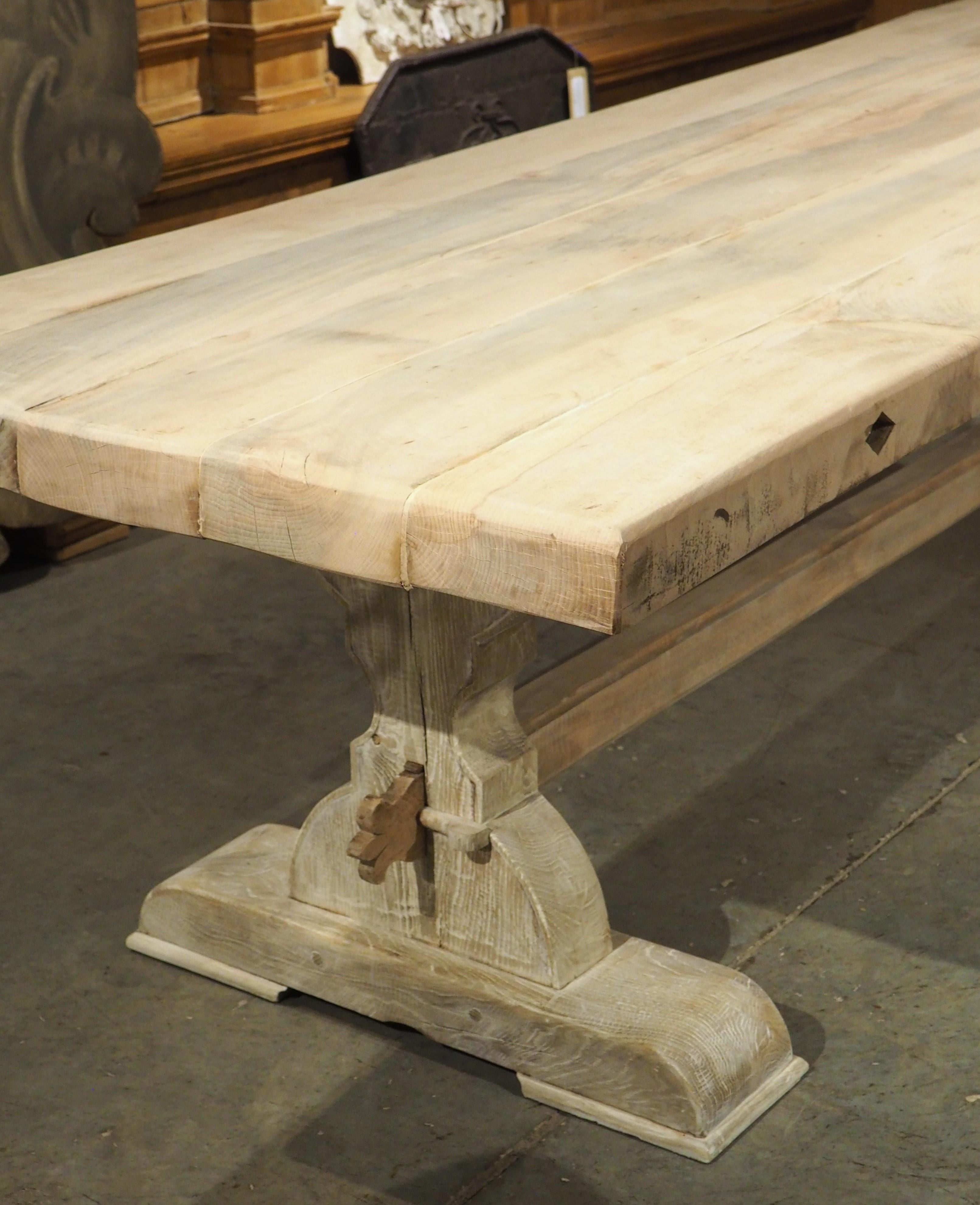 This monastery-style table from France is a magnificent dining table, measuring over 13 feet long. Hand-carved in the 1950s from both walnut and oak, the three-inch-thick top is comprised of five pieces of wood. The 157-inch long planks are kept