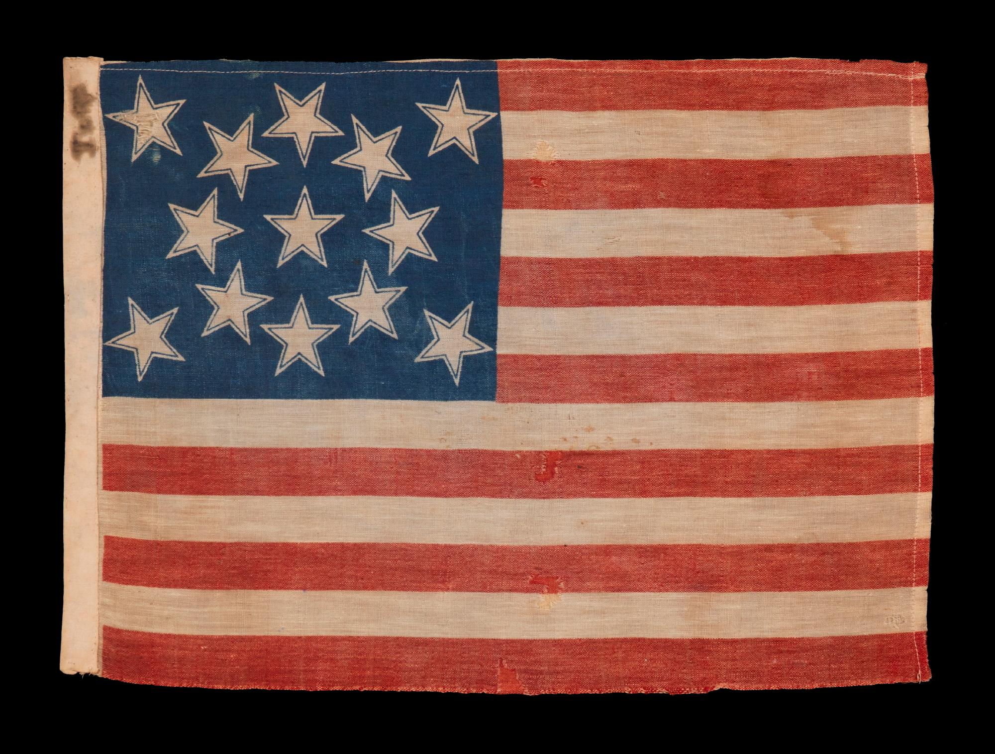 13 STELLE AUREOLATE IN UNA CONFIGURAZIONE A MEDAGLIONE, SU UNA BANDIERA AMERICANA ANTICA ECCEZIONALMENTE RARA REALIZZATA PER IL CENTENARIO DELL'INDIPENDENZA AMERICANA DEL 1876

Bandiera americana da parata a 13 stelle, stampata su un tessuto misto