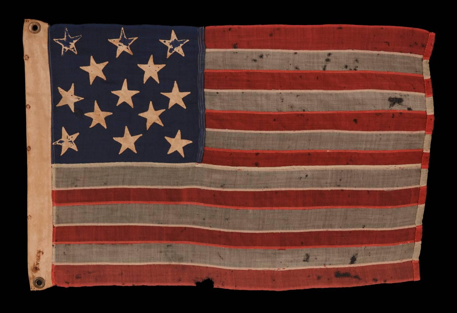 13 hand-sewn stars in a 3-2-3-2-3 pattern on an antique American flag with endearing wear from long-term use, and in an extraordinarily small amoung it's pieced-and-sewn counterparts, probably made during the American civil war (1861-65), though