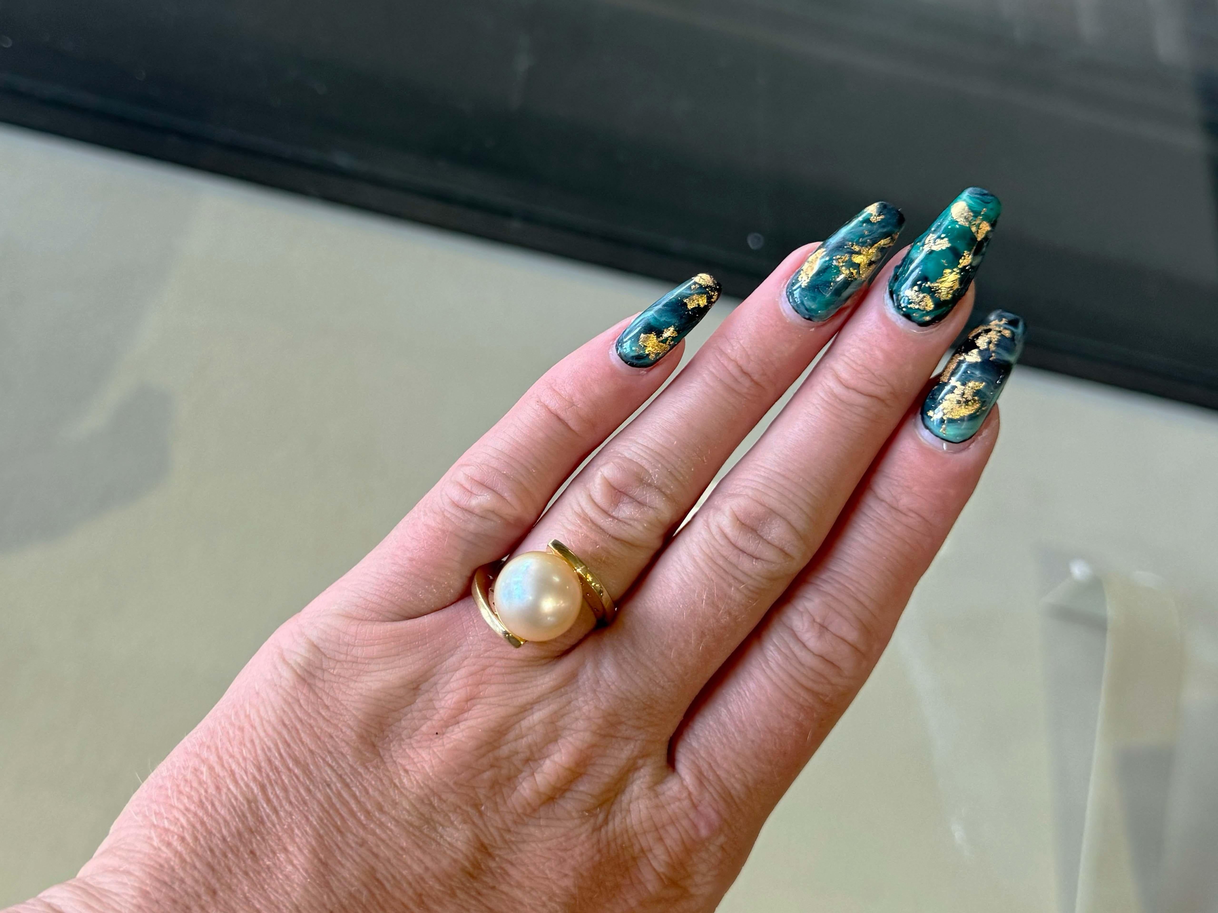 Ring Specifications:

Metal: 18k Yellow Gold

Total Weight: 11.1 Grams
​
​Pearl Diameter: 13 mm
​
​Pearl Count: 1 gold pearl

Diamond Count: 10 brilliant cut

Diamond Color: G

Diamond Clarity: VS2

Diamond Carat Weight: 0.20 carats

Ring Size: 