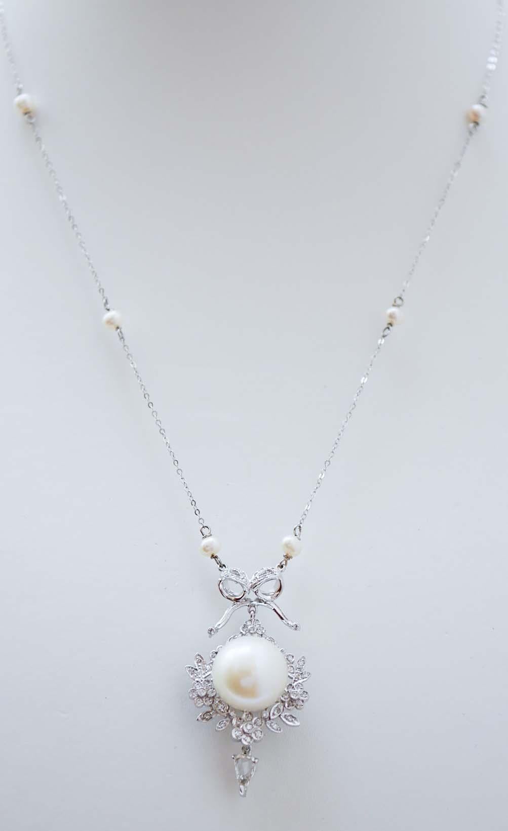 Magnifique pendentif en platine monté avec une perle centrale entourée de diamants et une goutte de diamant en pendentif. La chaîne est en or blanc 9 kt et, le long de celle-ci, des perles.
Ce collier a été entièrement réalisé à la main par des