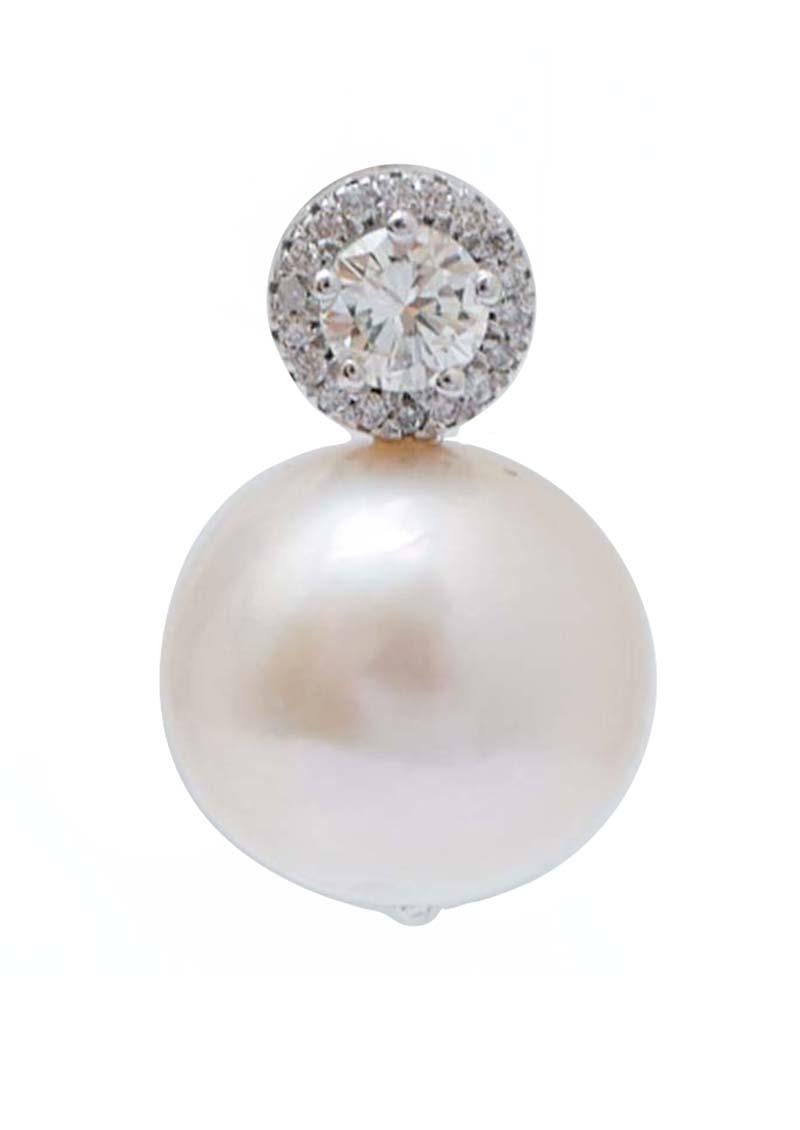 Elegantes boucles d'oreilles en structure d'or blanc 14 kt montées avec un plus gros diamant central entouré de diamants. Comme pendentif, une perle.
Ces boucles d'oreilles ont été entièrement réalisées à la main par des maîtres orfèvres italiens et